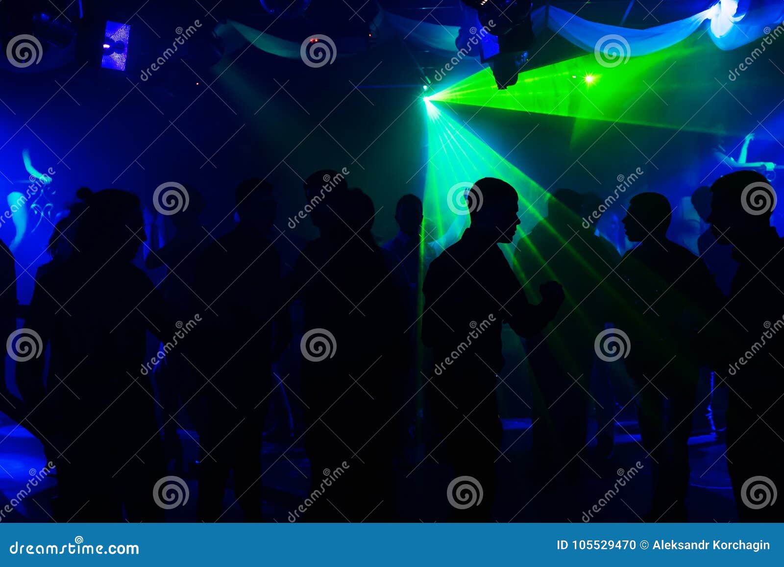 People silhouettes on the dance floor of a night club at the event under th...