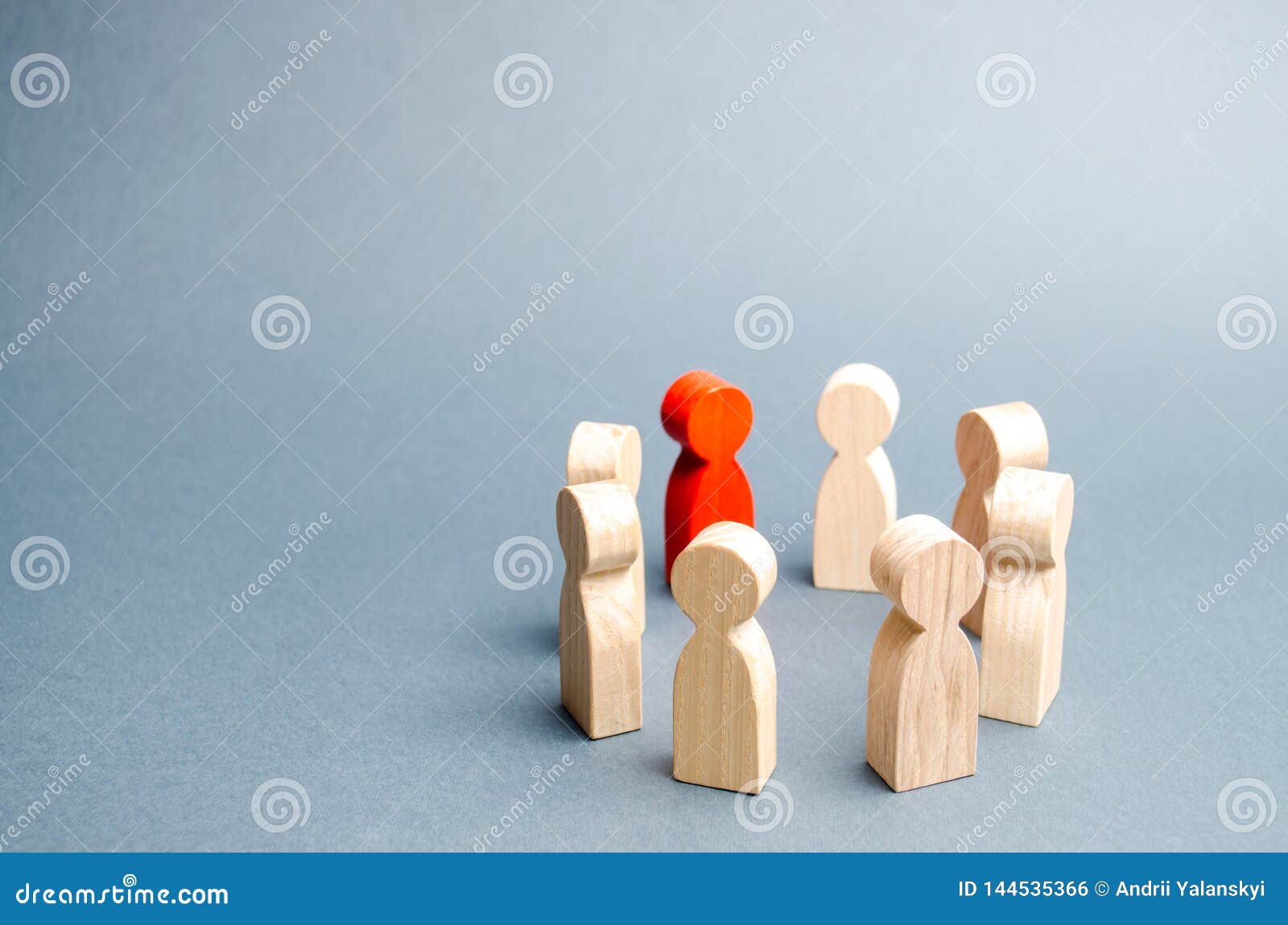 people stand in a circle on a gray background. communication. business team, teamwork, team spirit. wooden figures of people. a