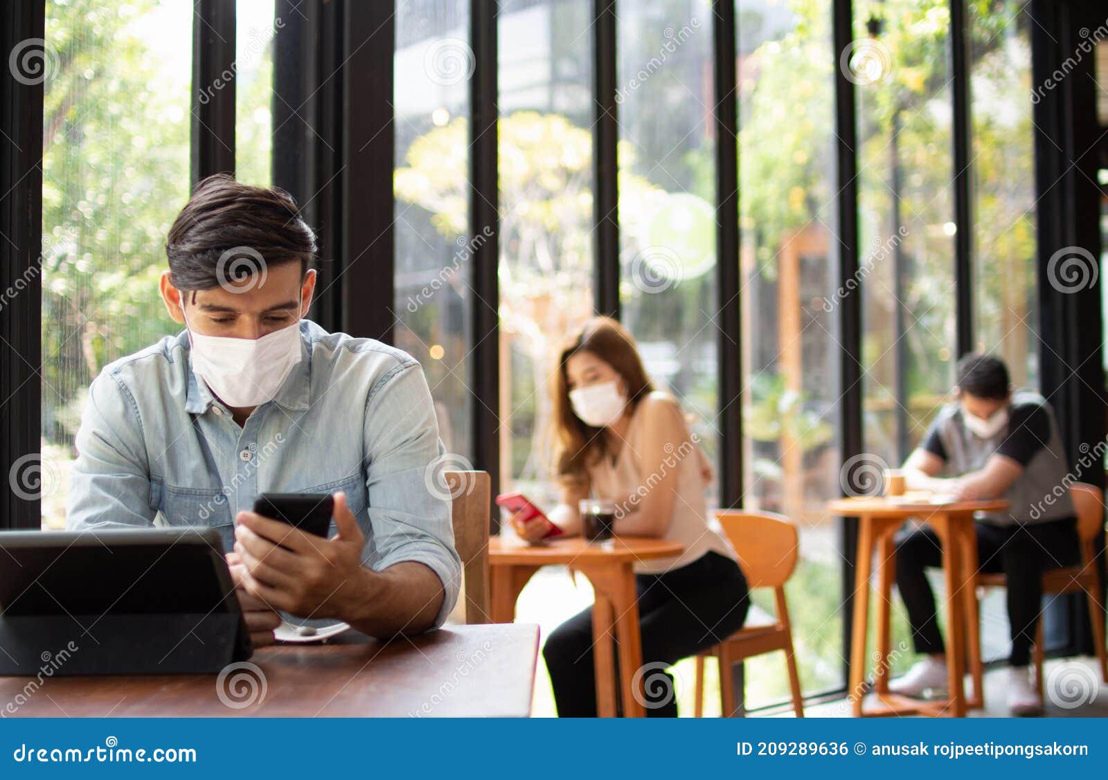 people wearing surgical masks are sitting in restaurants, coffee shops. social distancing concept healthcare pandemic. public
