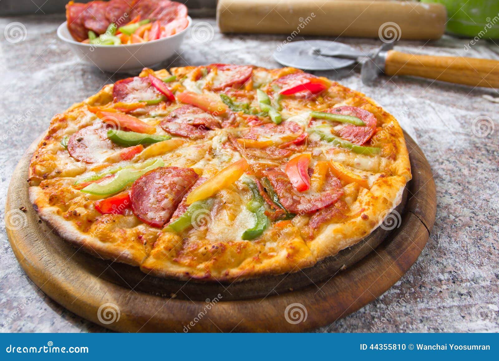 Pepperoni da pizza na placa de madeira na cozinha