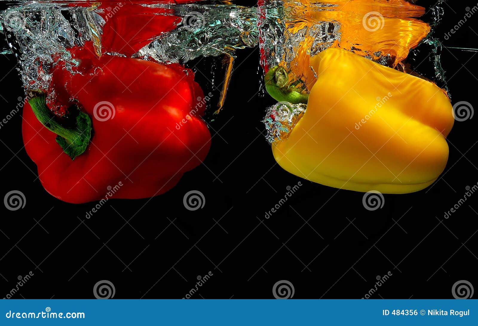 Yellow and red peppers falling into water