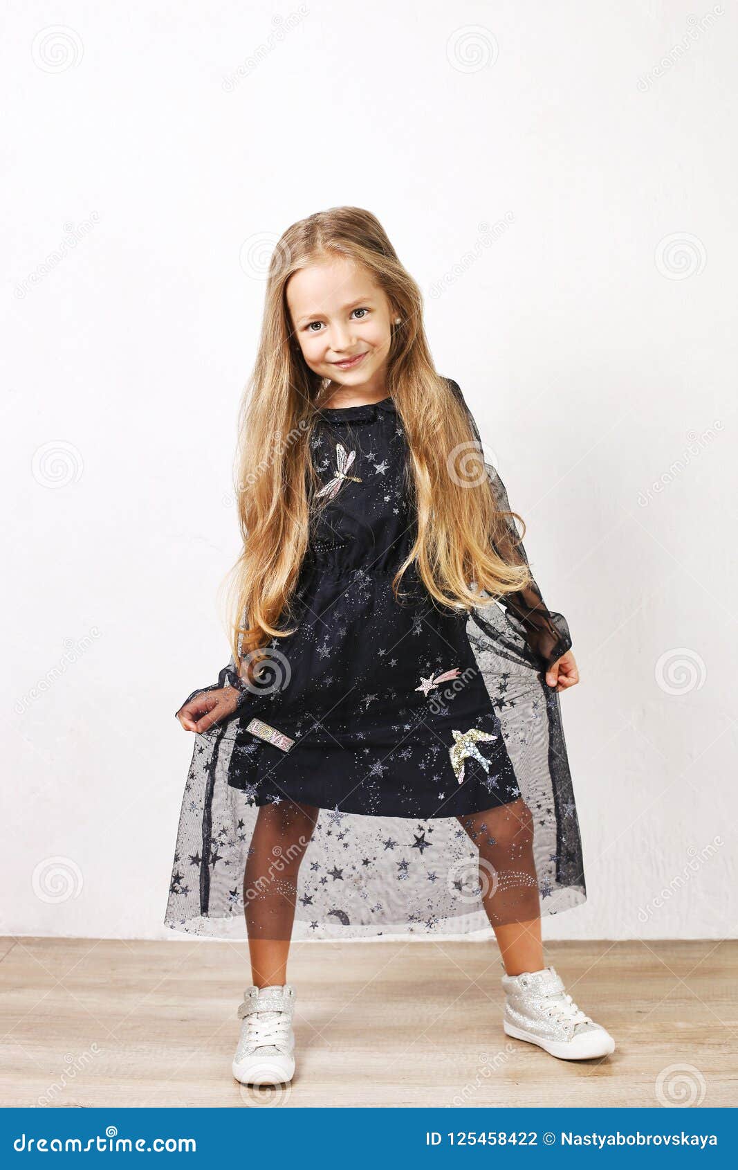 Ministerio Illinois libro de texto Pequeña Muchacha Rubia Con El Pelo De Oro Largo Que Lleva El Vestido Negro  Con Las Estrellas Y Los Planetas, Baile, Smling Y Divi Foto de archivo -  Imagen de santifica, oscuro: