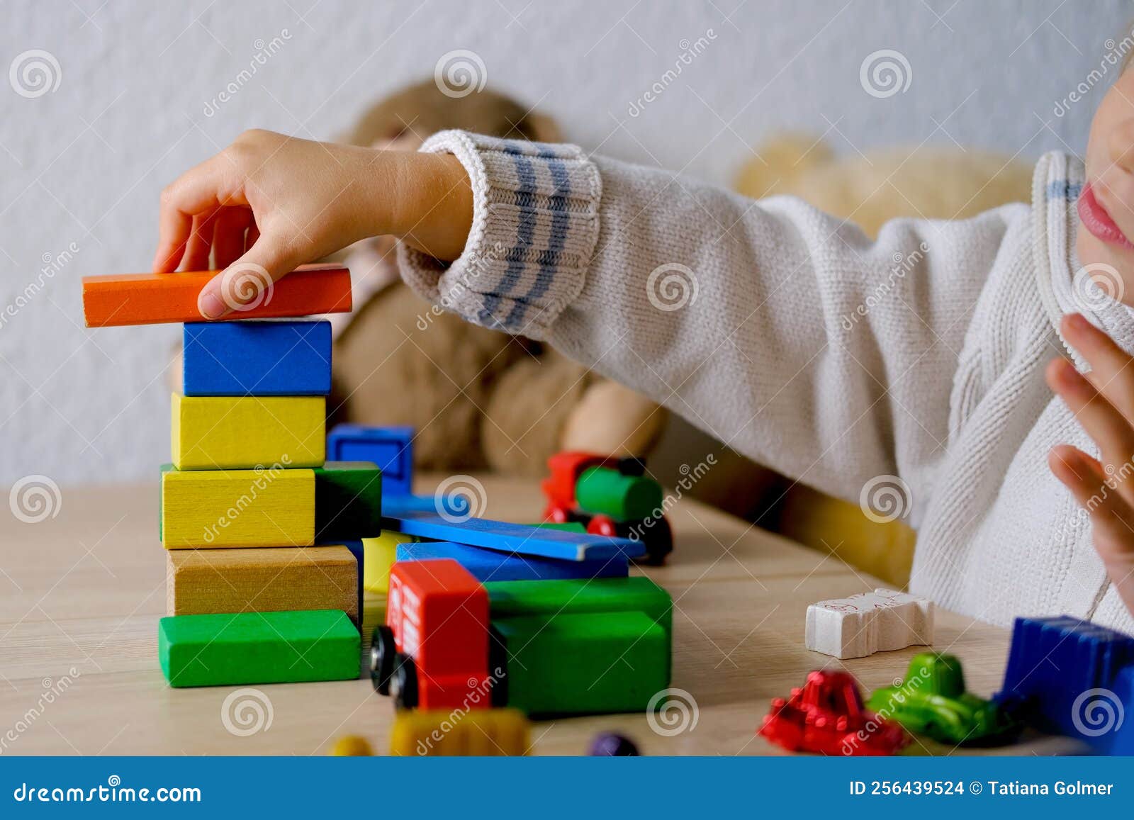 Pequeña Niña Rubia De 3 Años Juega Juguetes Construye Torres Y Edificios a  Partir Del Concepto De Figuras De Madera De Color Foto de archivo - Imagen  de gente, casa: 256439524