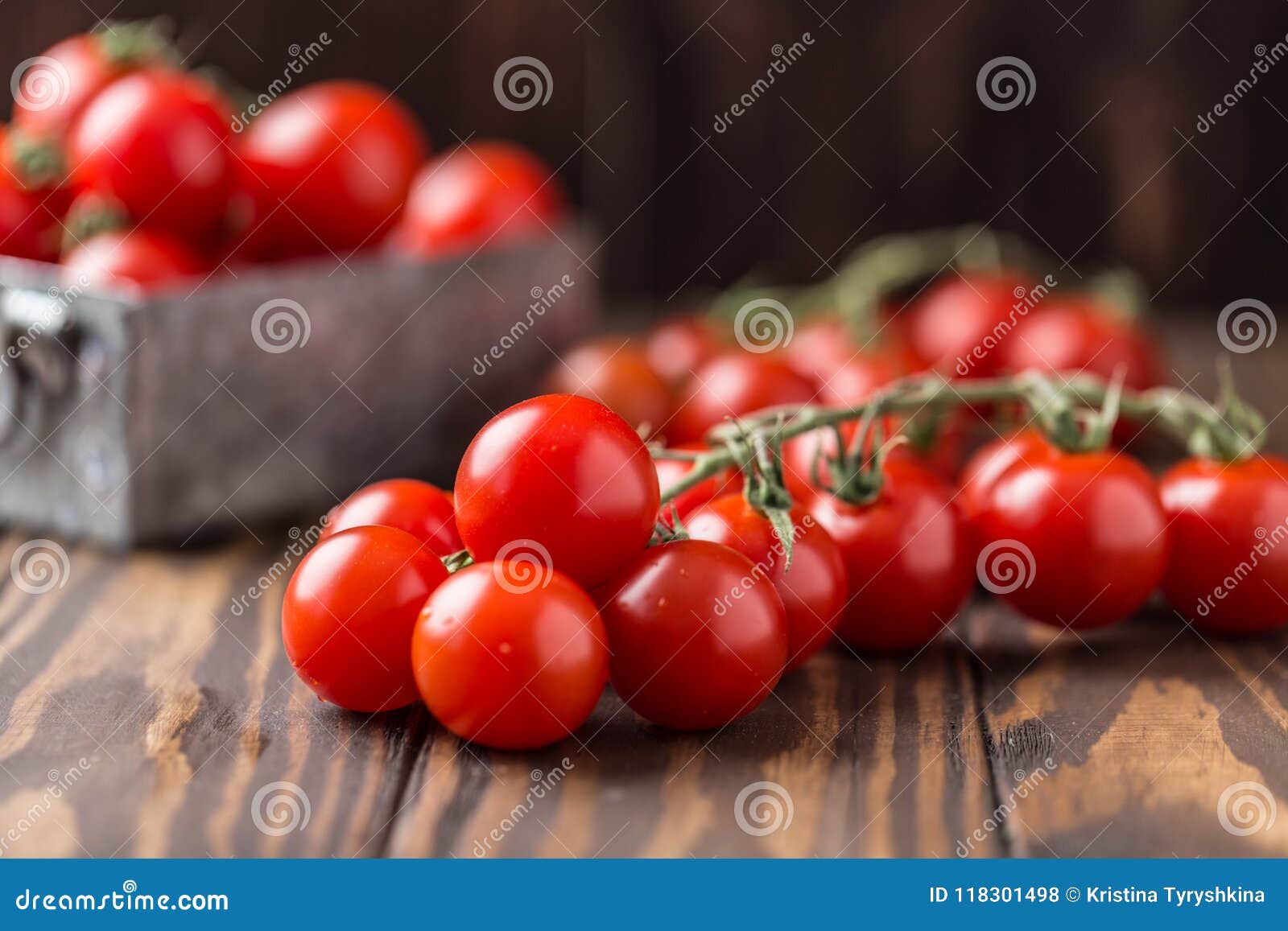 Pequeños tomates de cereza rojos en fondo rústico Tomates de cereza en la vid