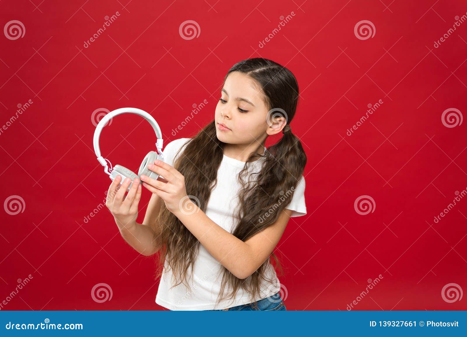 perfect for clear sound of music. adorable music fan with wireless headset in hands. little child using technology for