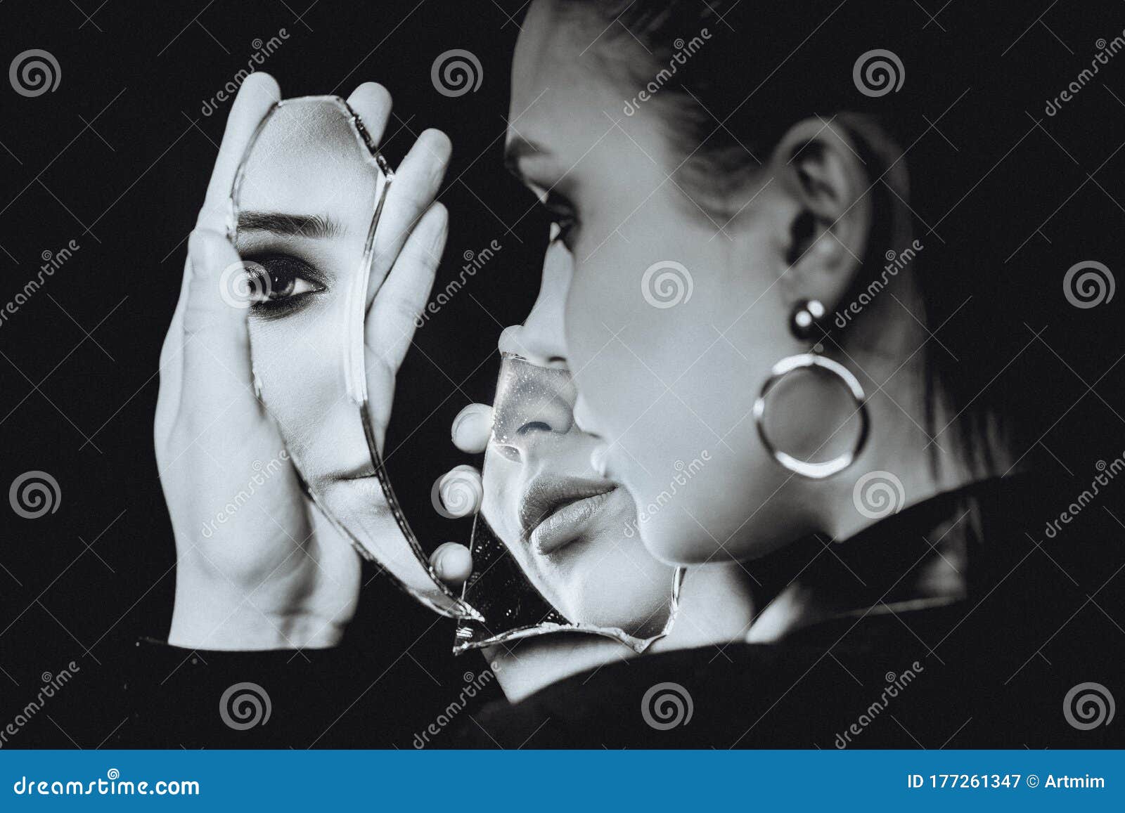 perfect woman looking at broken mirror on black background, black and white portrait
