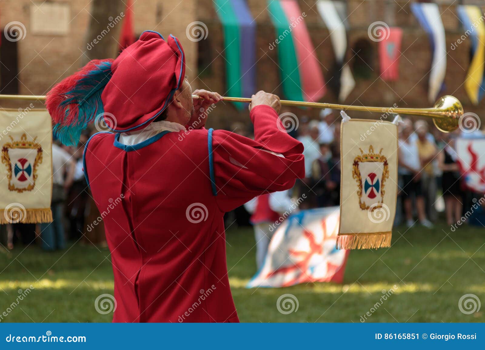 Performer Dressed in Red with Long Trumpet during Procession Editorial