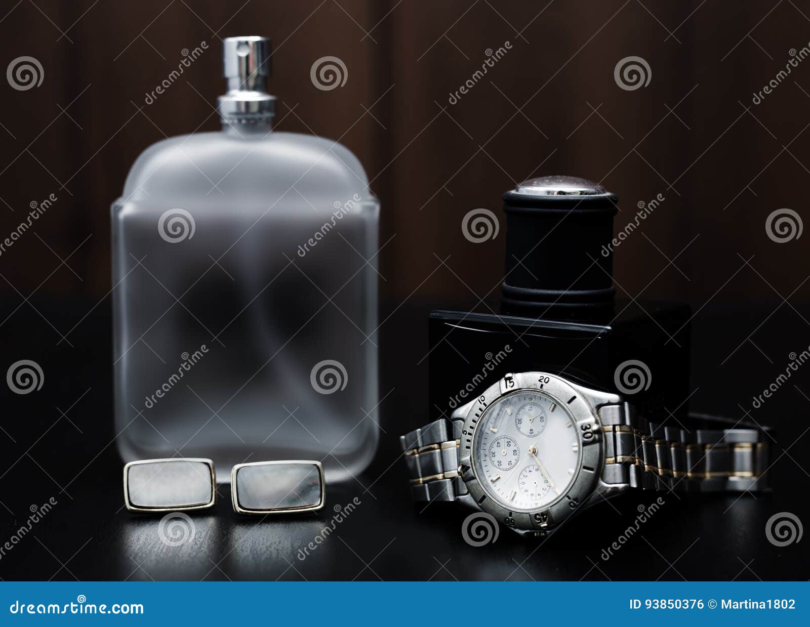 perfume and watches on a wooden background. men`s accessori