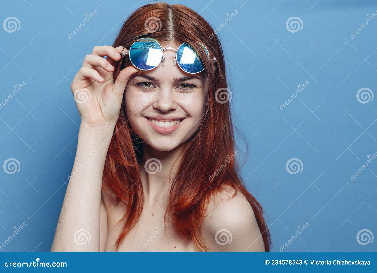 Perky Red Haired Woman In Blue Glasses Bare Shoulders Posing Stock