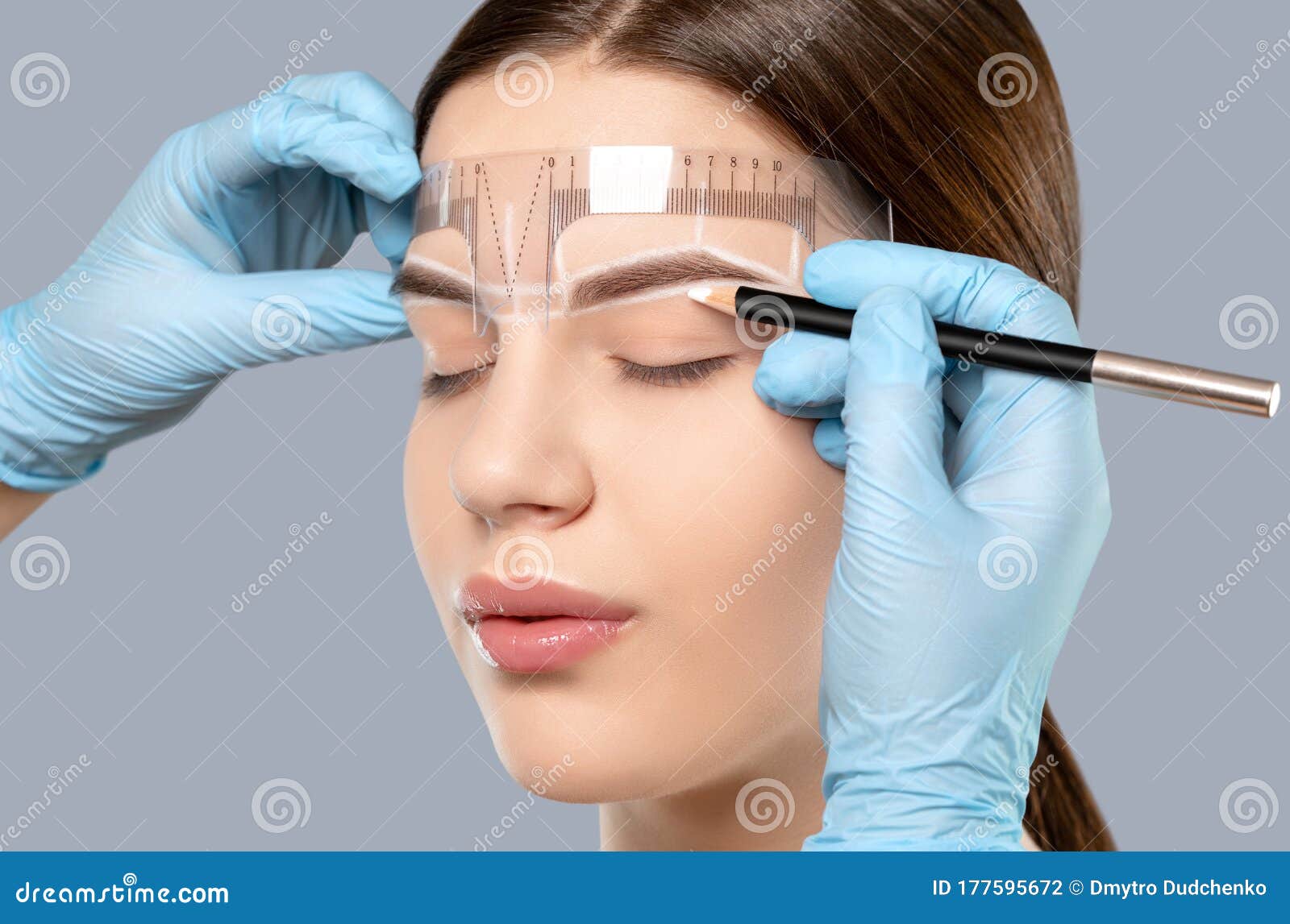 permanent make-up for eyebrows of beautiful woman with thick brows in beauty salon. closeup beautician doing tattooing eyebrow.