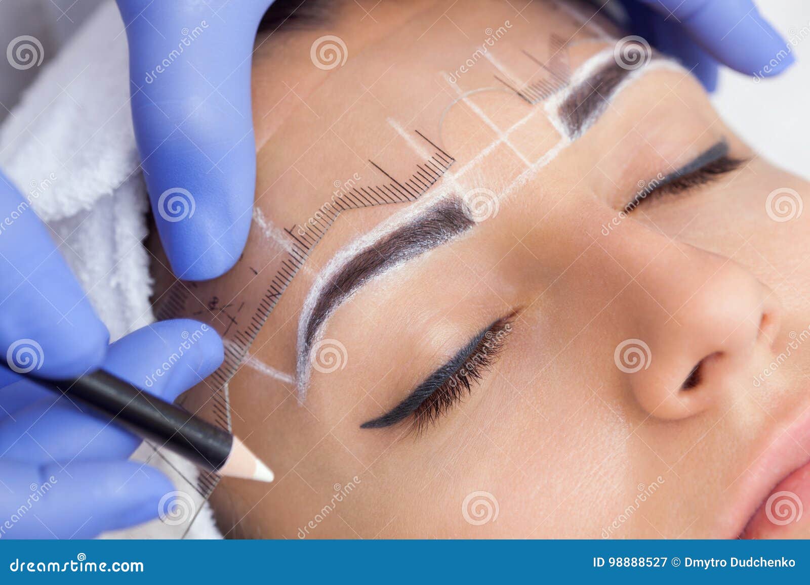 permanent make-up for eyebrows of beautiful woman with thick brows in beauty salon