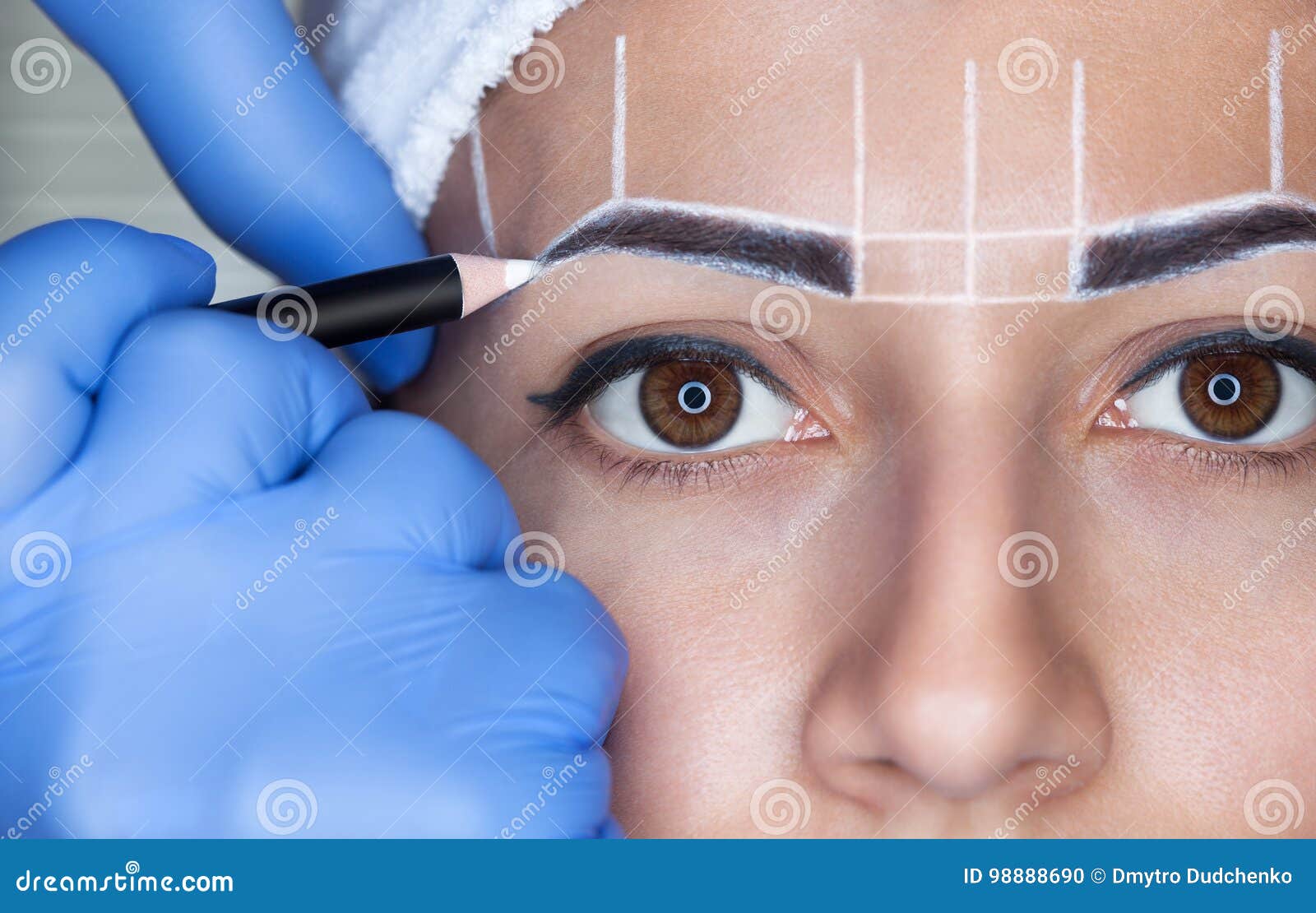 permanent make-up for eyebrows of beautiful woman with thick brows in beauty salon.