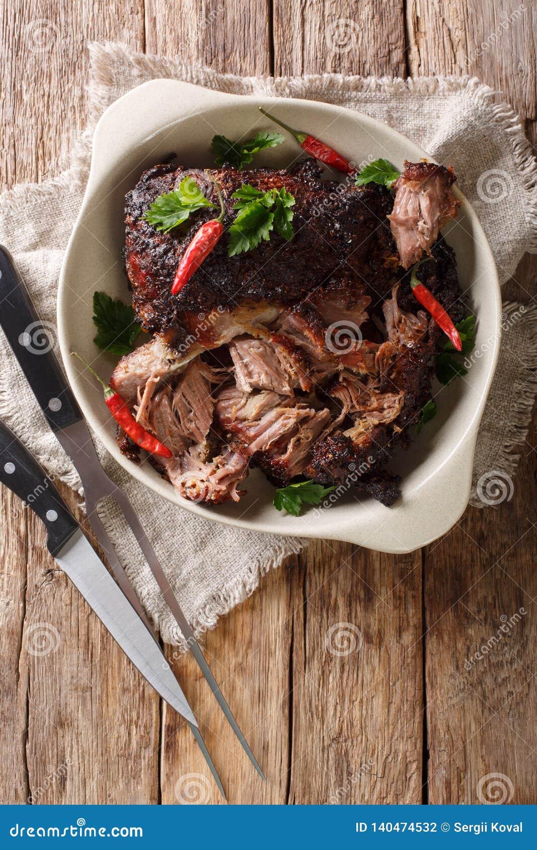 pernil asado slow cooked shredded pulled pork close-up on a plate. vertical top view