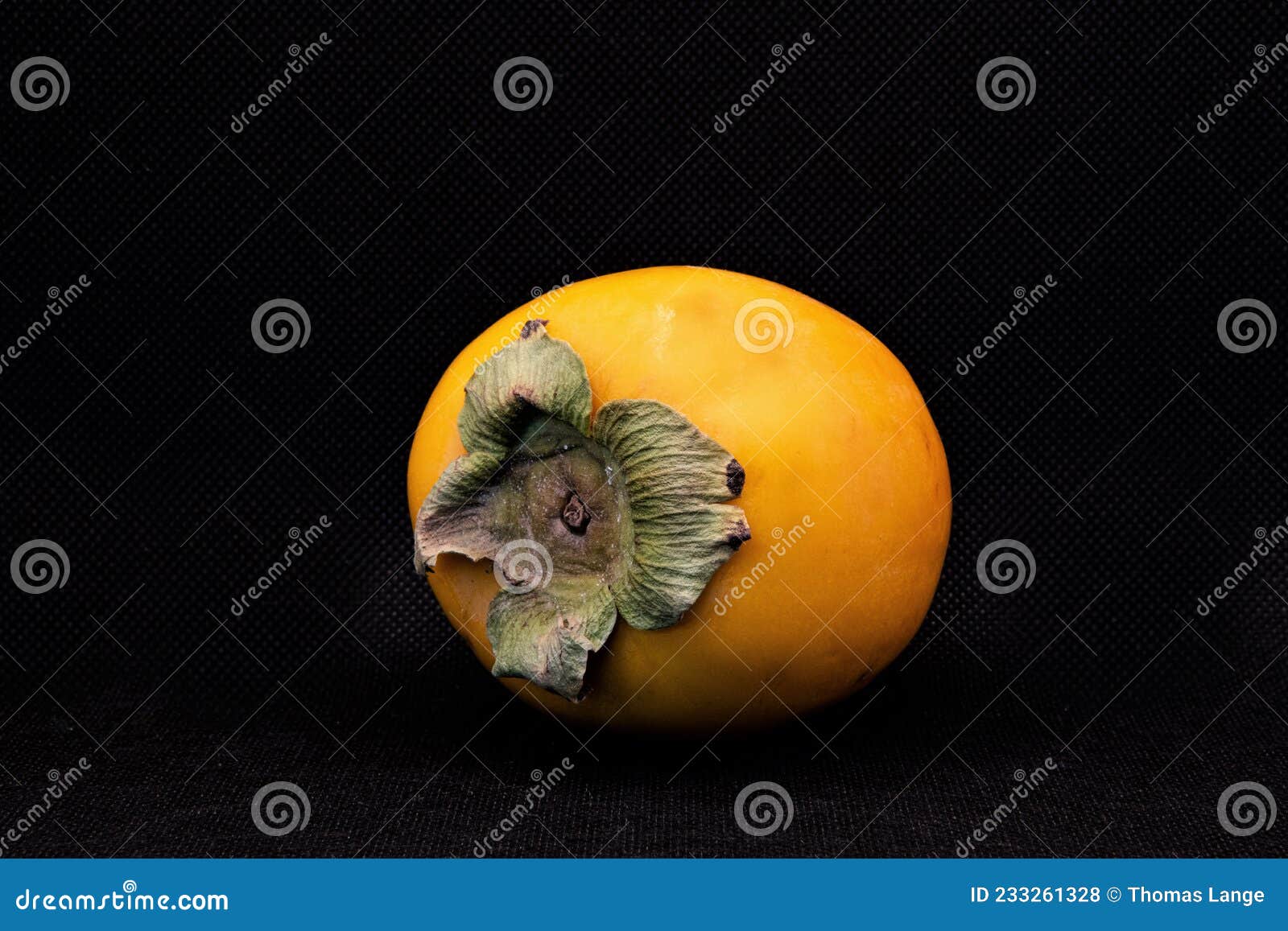 persimmon or kakhi in front of a dark background
