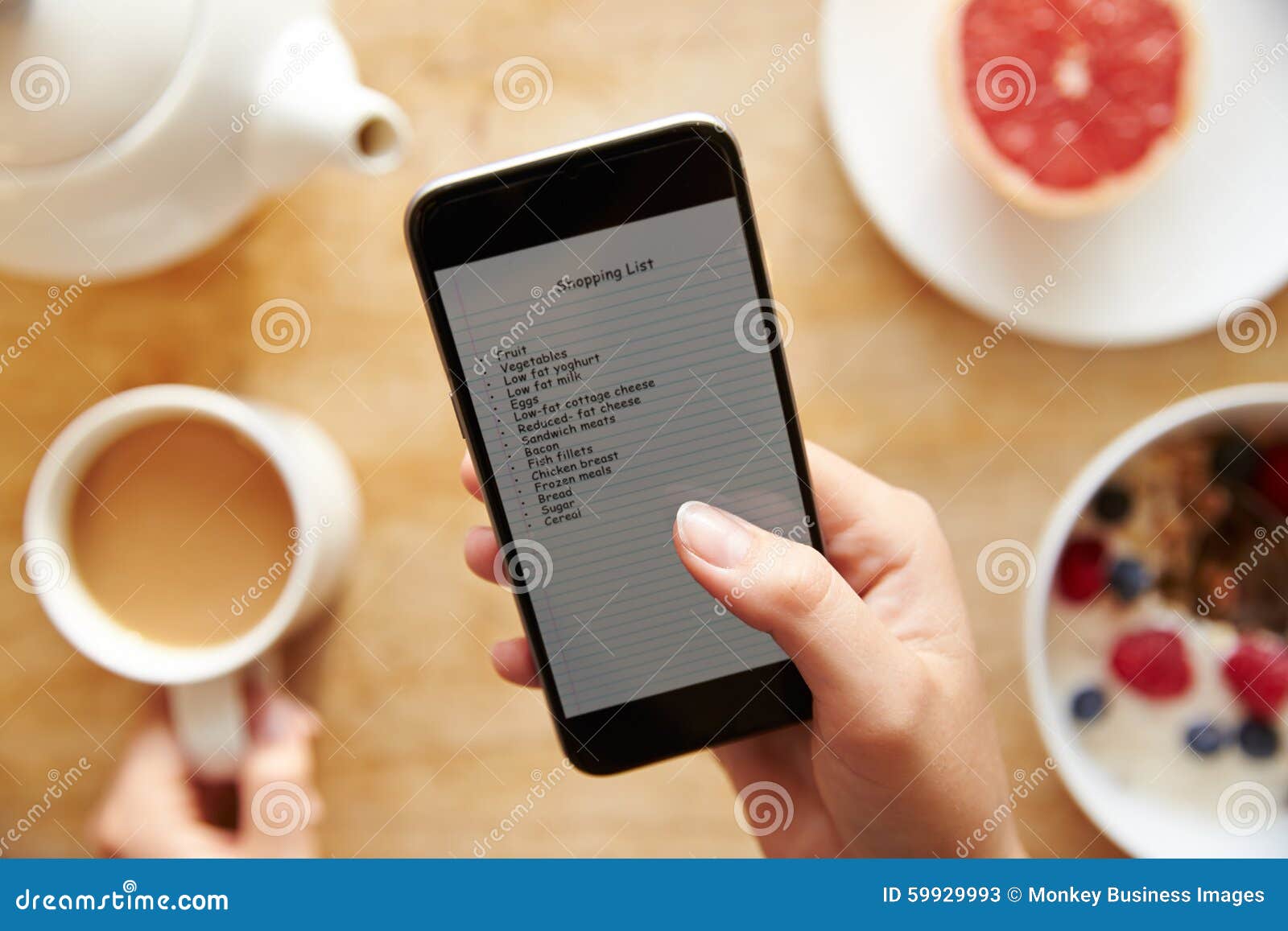 person at breakfast looking at to do list on mobile phone