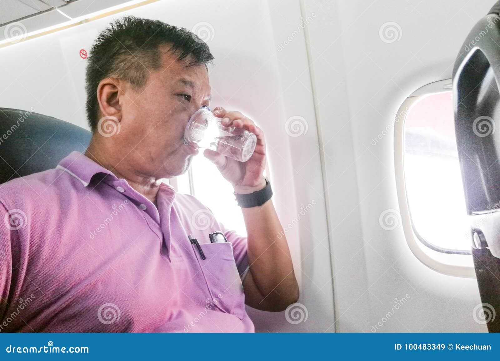 person drinking water in airplane long haul flight to hydrate