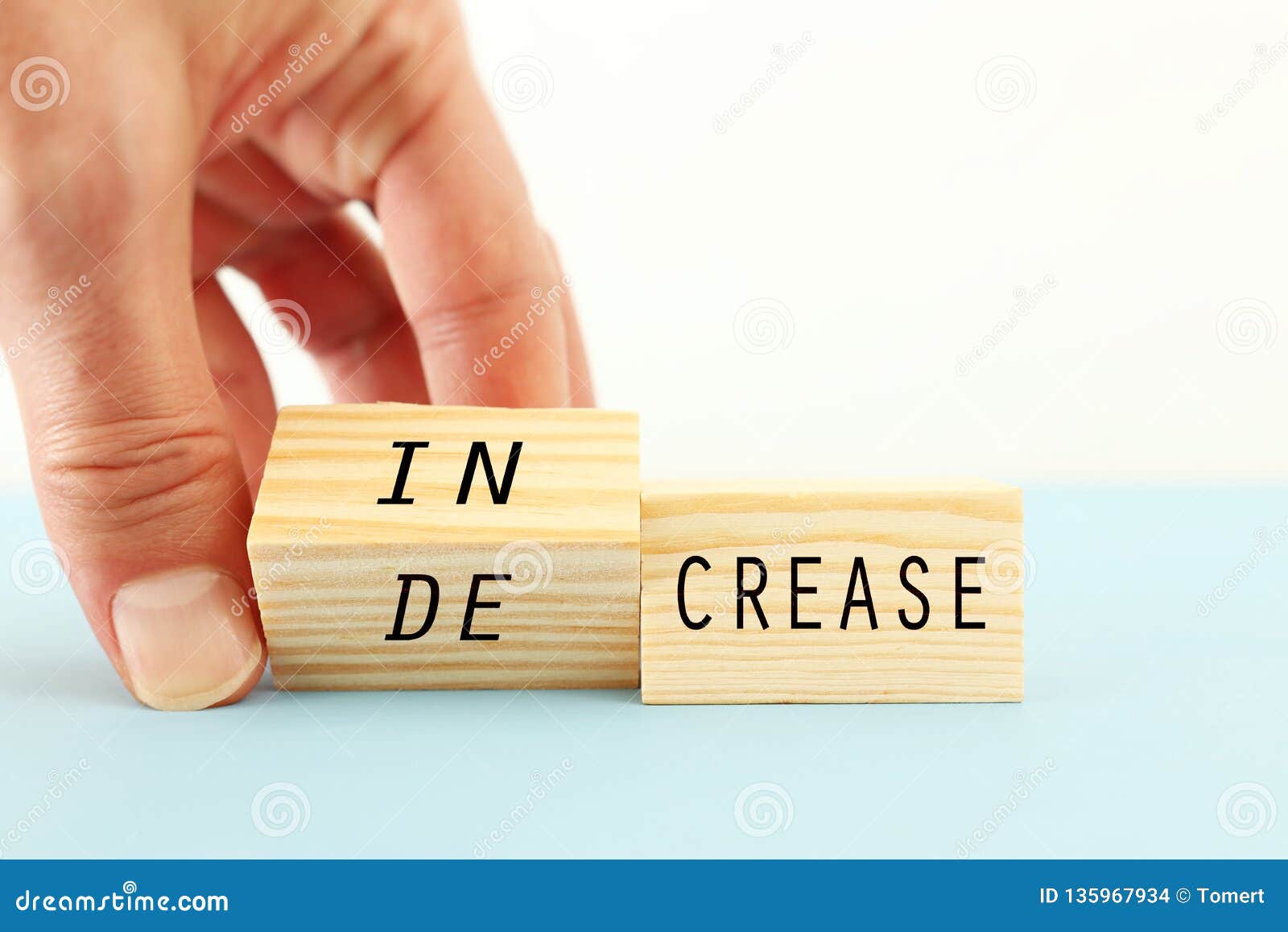 person hand flipping wooden cubes so that it will be written increase instead of decrease. business development and positive.