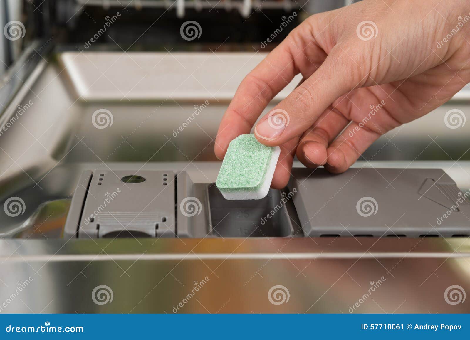 Putting Tab Into Dishwasher, Close Up. A Man Hand Holding Dishwasher