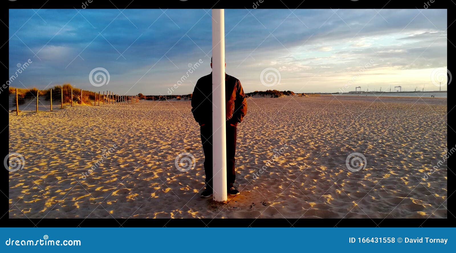 Person Hidden Behind a Pole Stock Photo picture