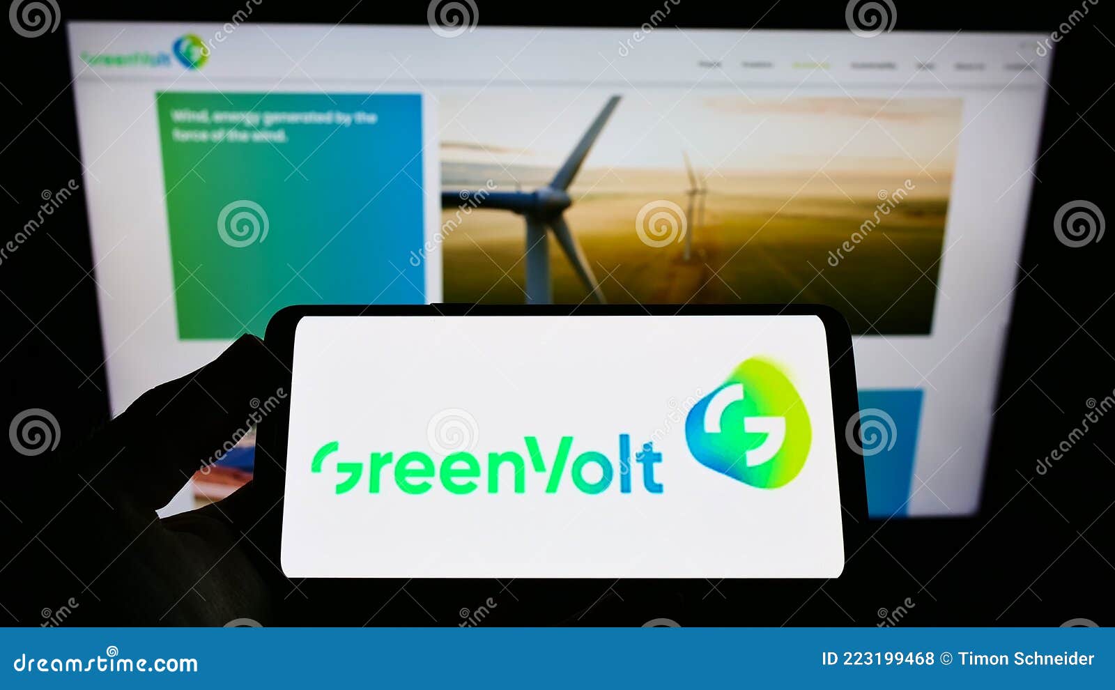 Person holding cellphone with logo of energy company Greenvolt Energias RenovÃ¡veis SA on screen in front of business webpage.