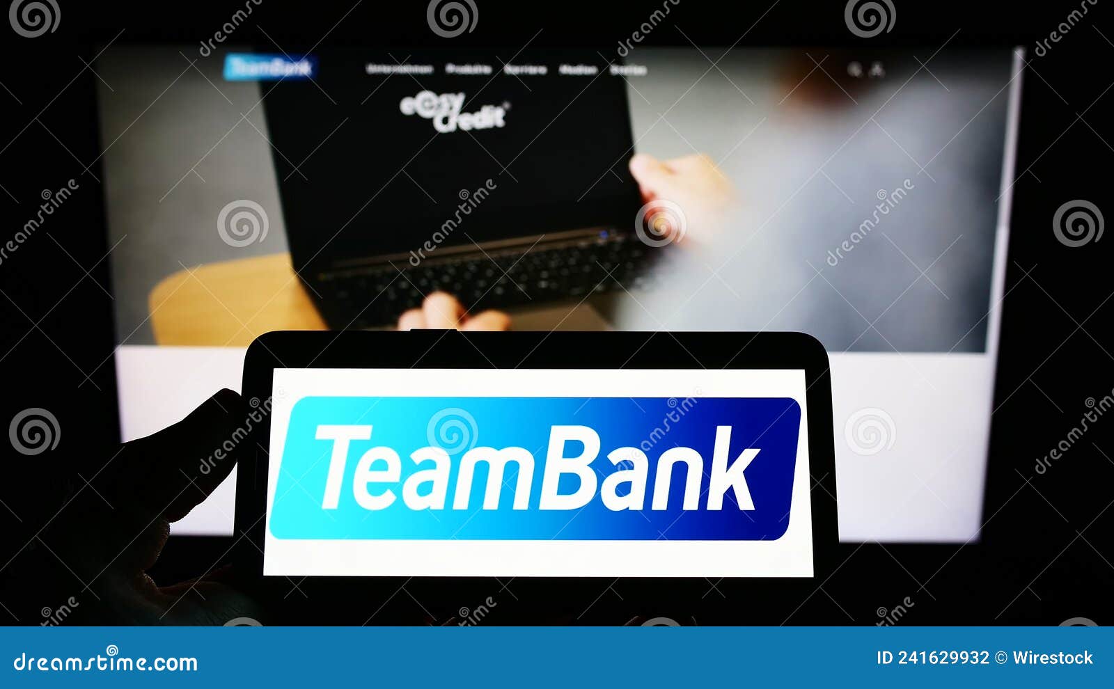 Person Holding Mobile Phone with Logo of Company TeamBank AG Nurnberg