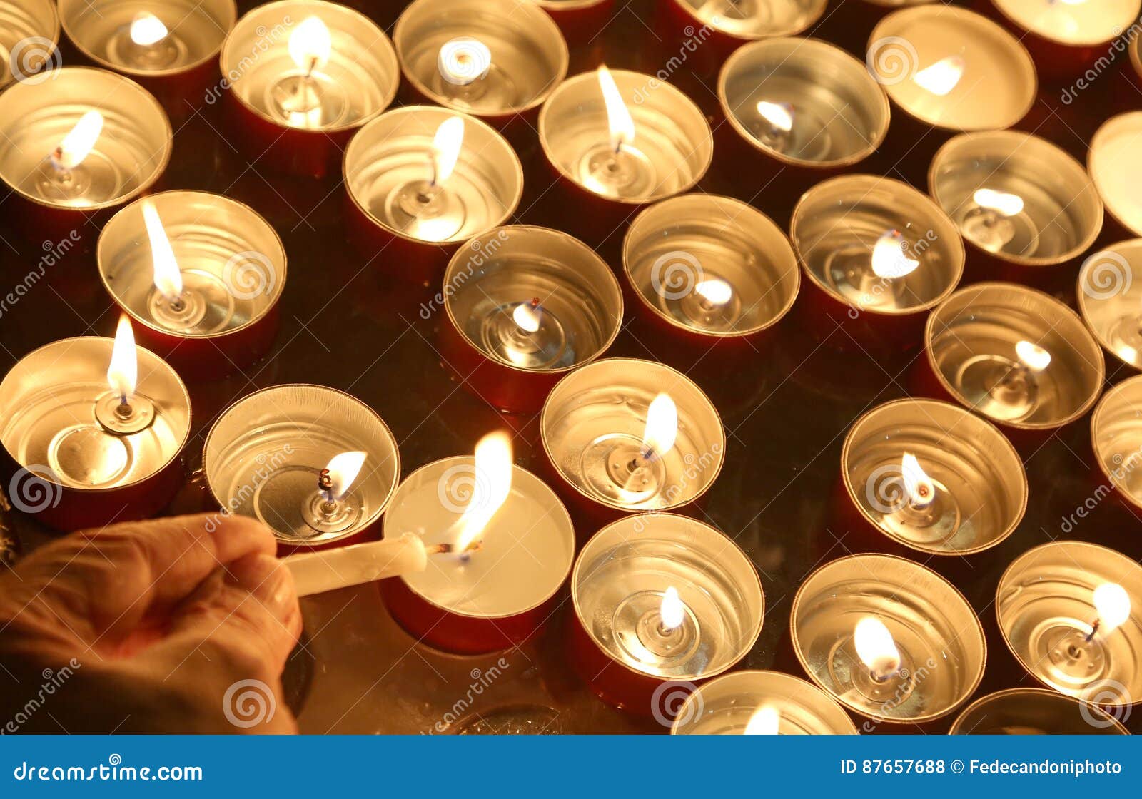 Person Lights a Candle during the Religious Ceremony Stock Photo