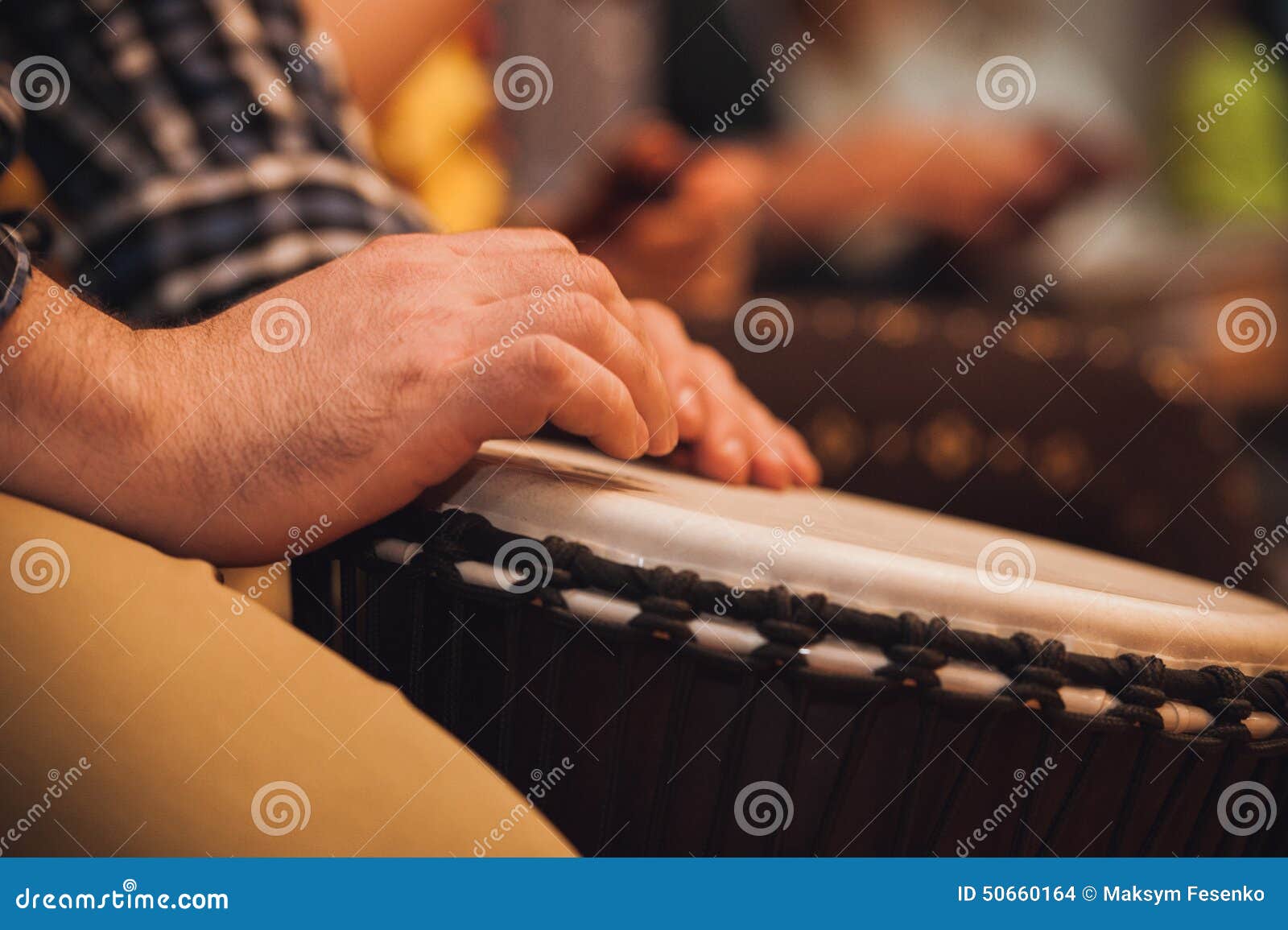 person playing on jambe drum no face