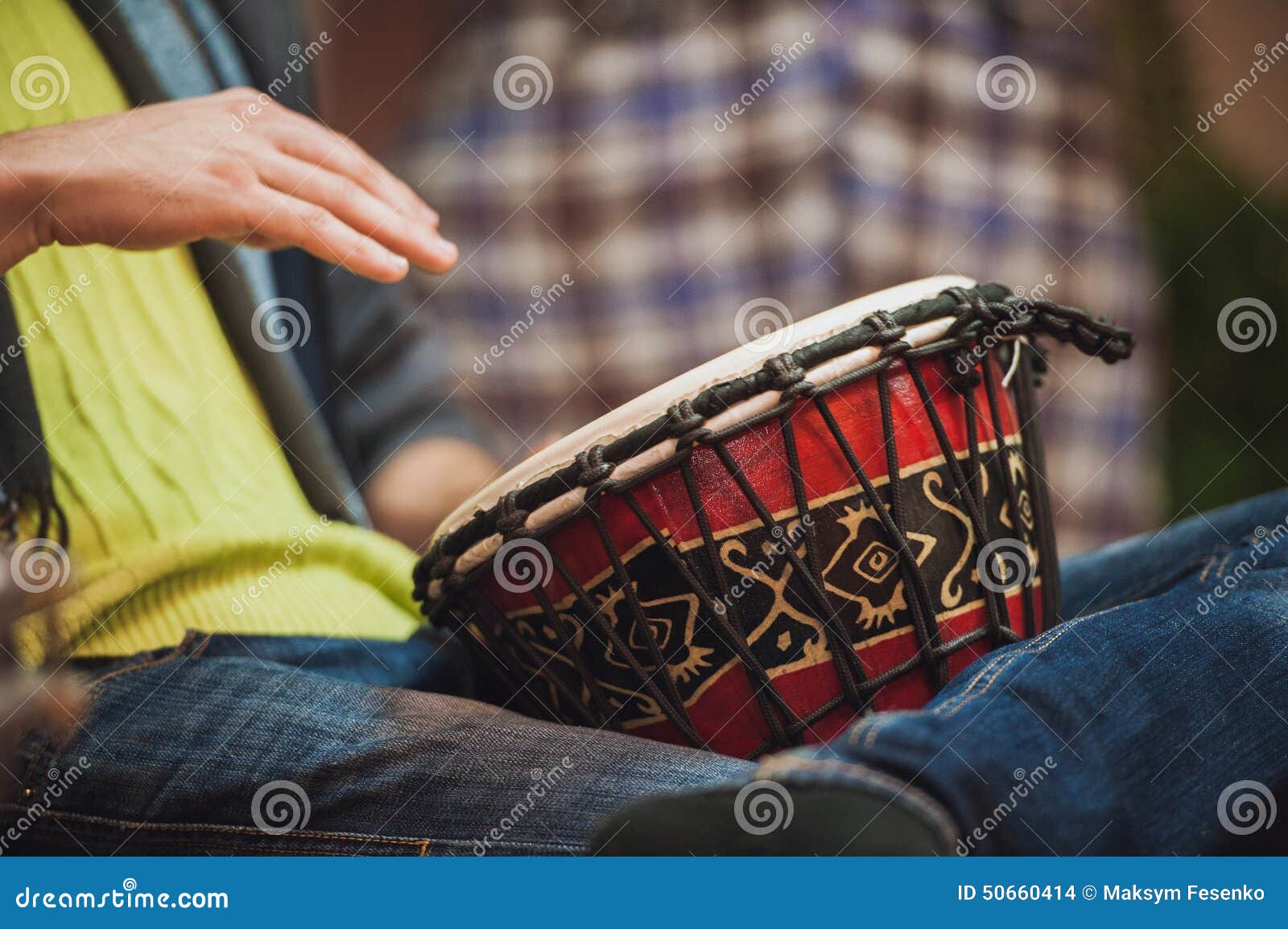 person playing on jambe drum no face