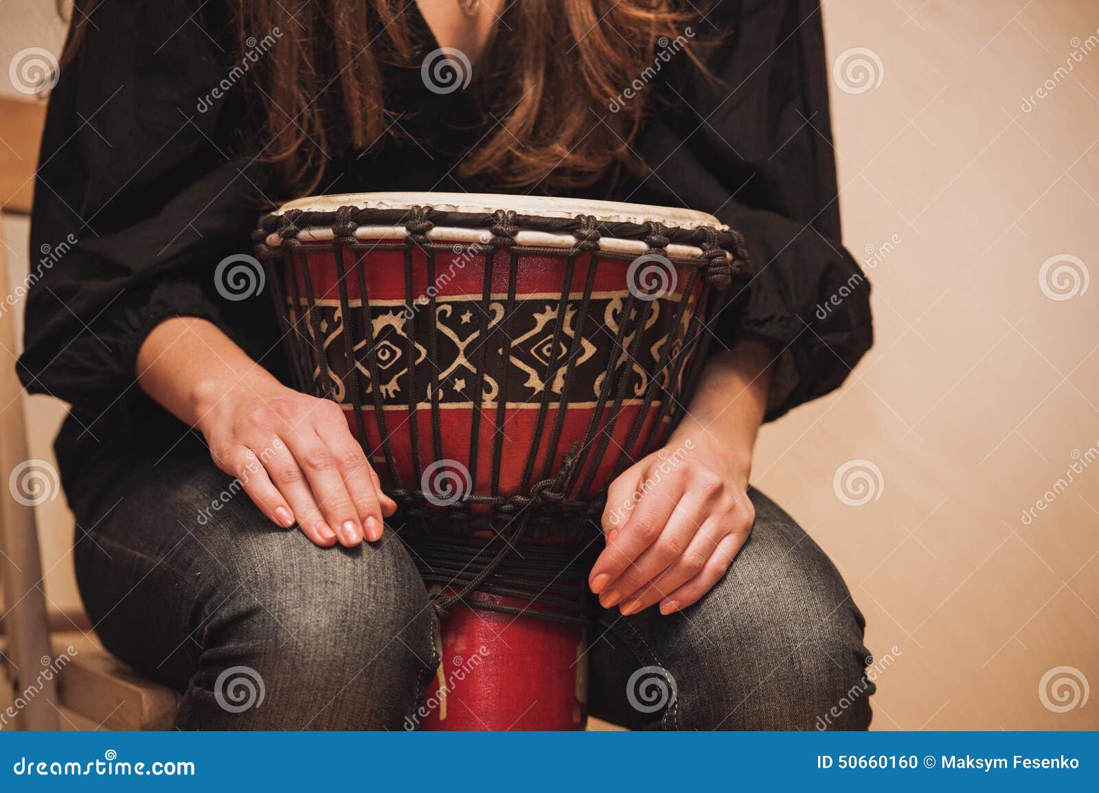 person playing on jambe drum no face