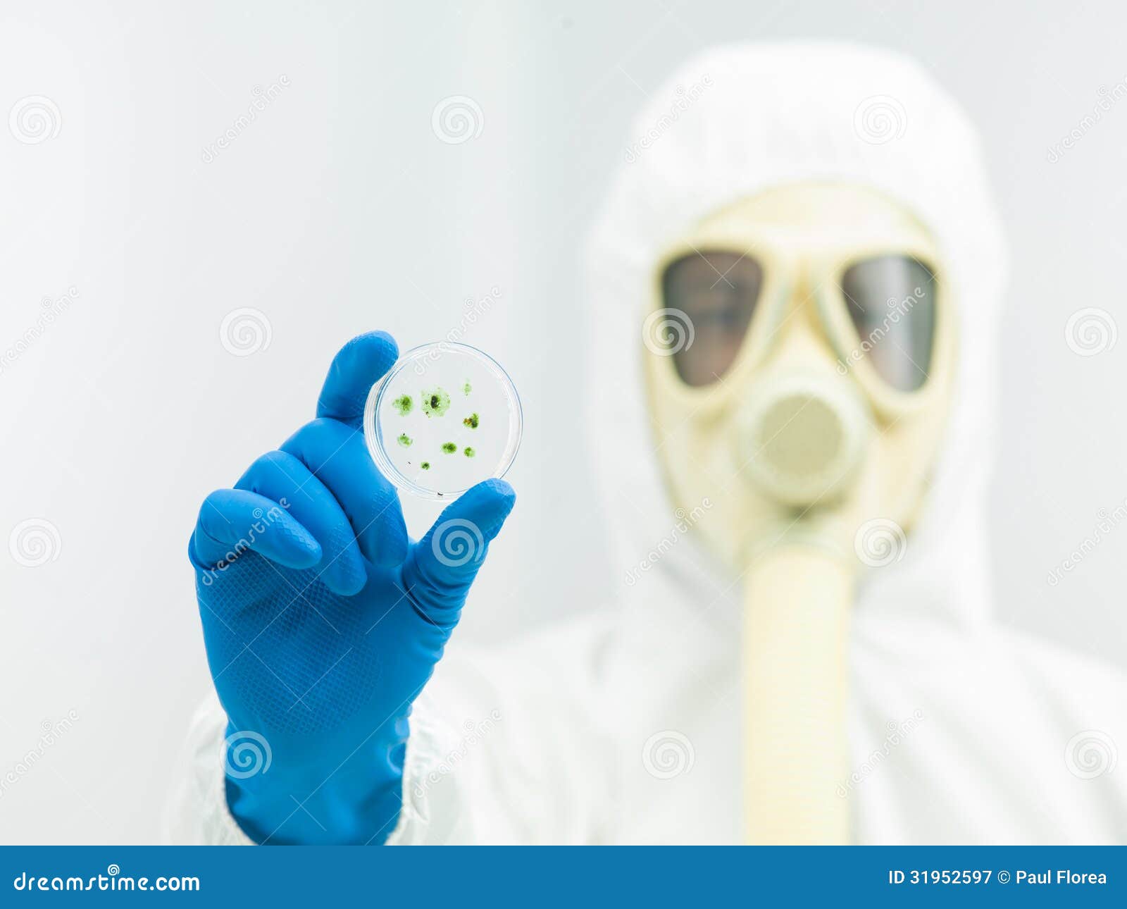 person in protective suit holding microorganism sample