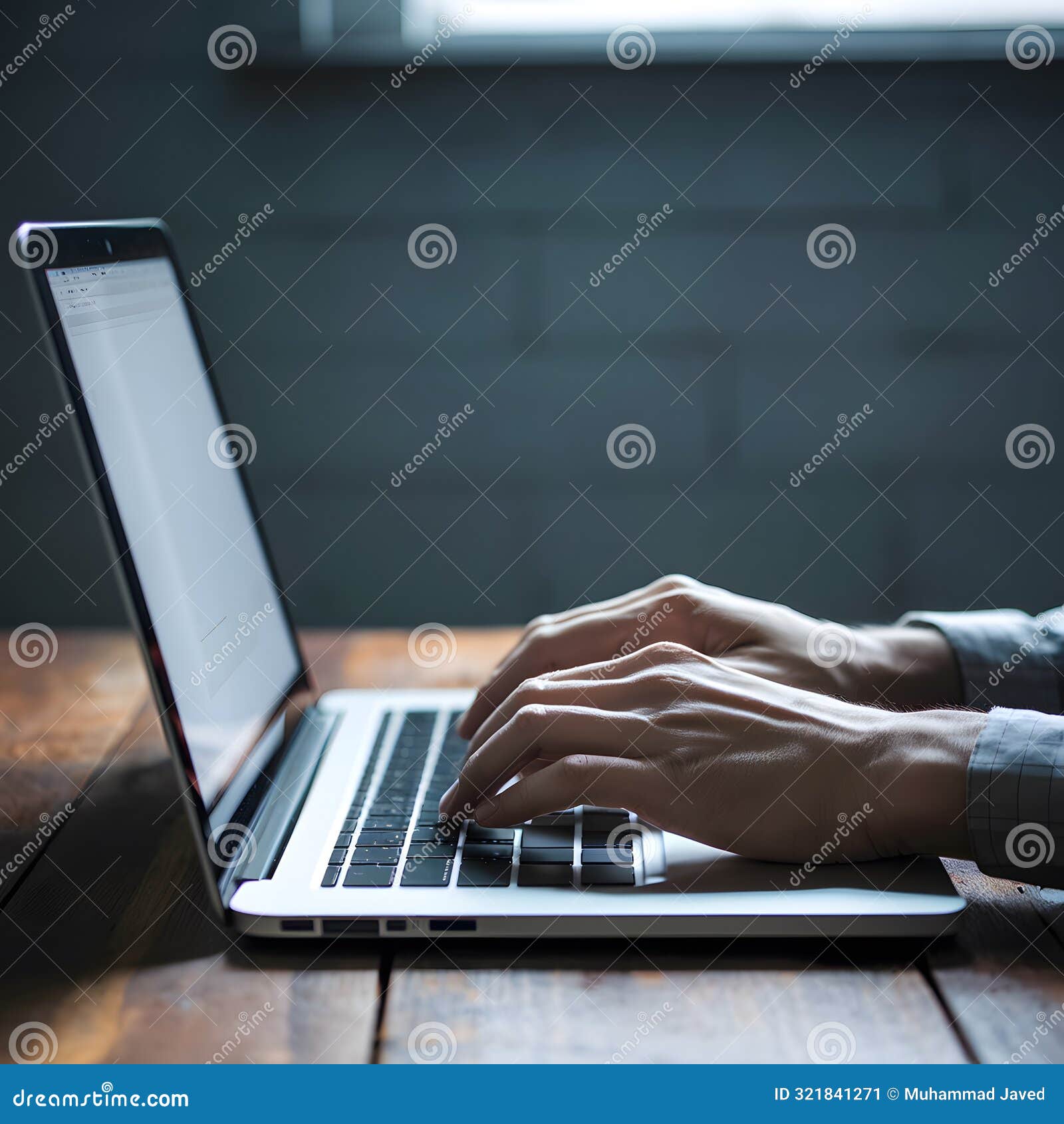 person typing on laptop, white screen, wooden table serene, focused ambiance with dim lighting