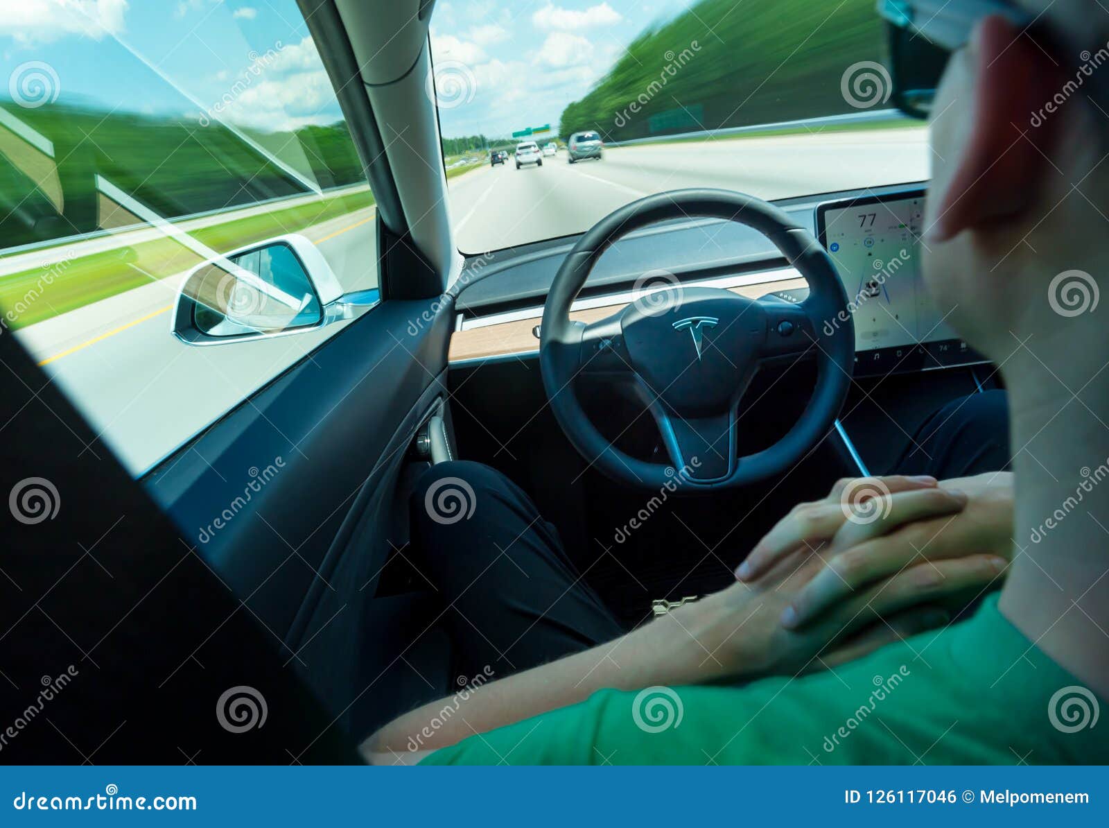 Person Using the Selfdriving Function in an All Electric Tesla Model 3