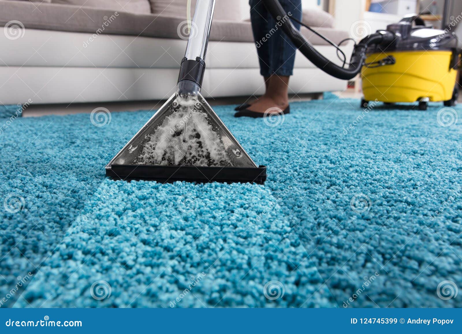 person using vacuum cleaner for cleaning carpet