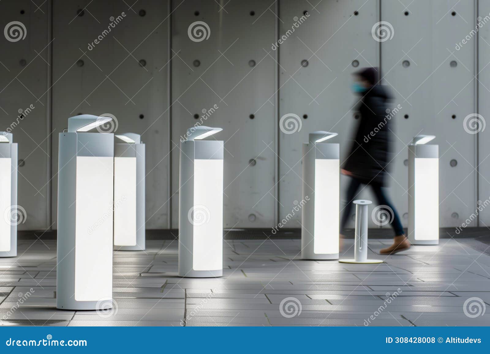 person walking past a series of white, sleek, energyefficient light fixtures