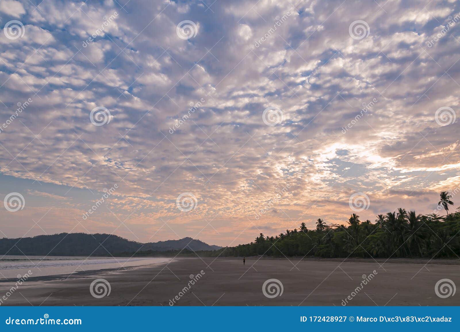 person walking in a sunset at tambor beach, puntarenas costa rica