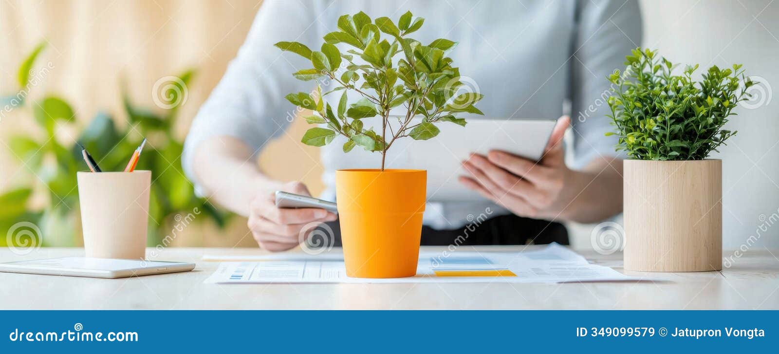 a person working with plants and digital tools in a bright workspace environment