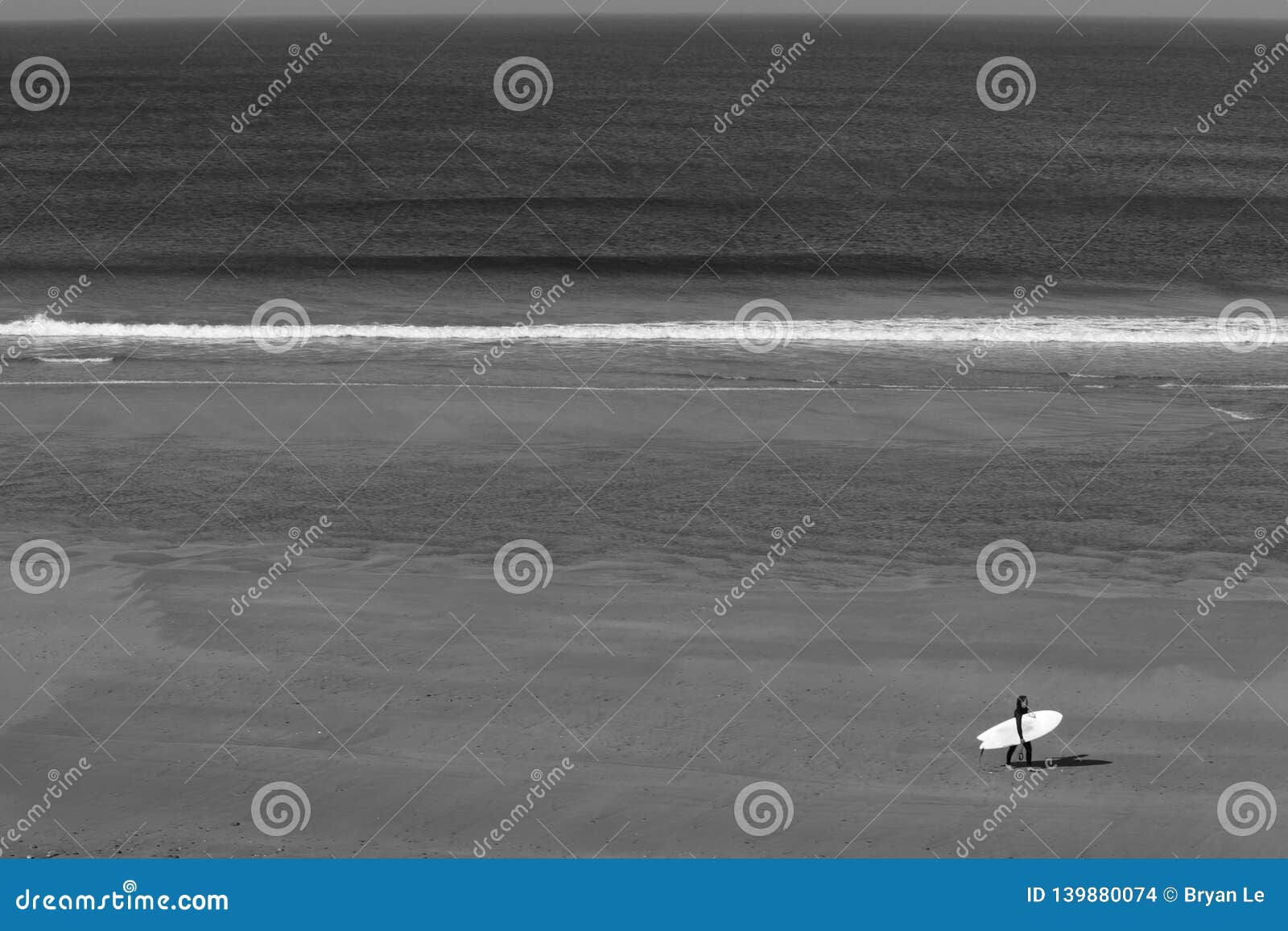 Persona que practica surf sola que camina en la playa en negro y