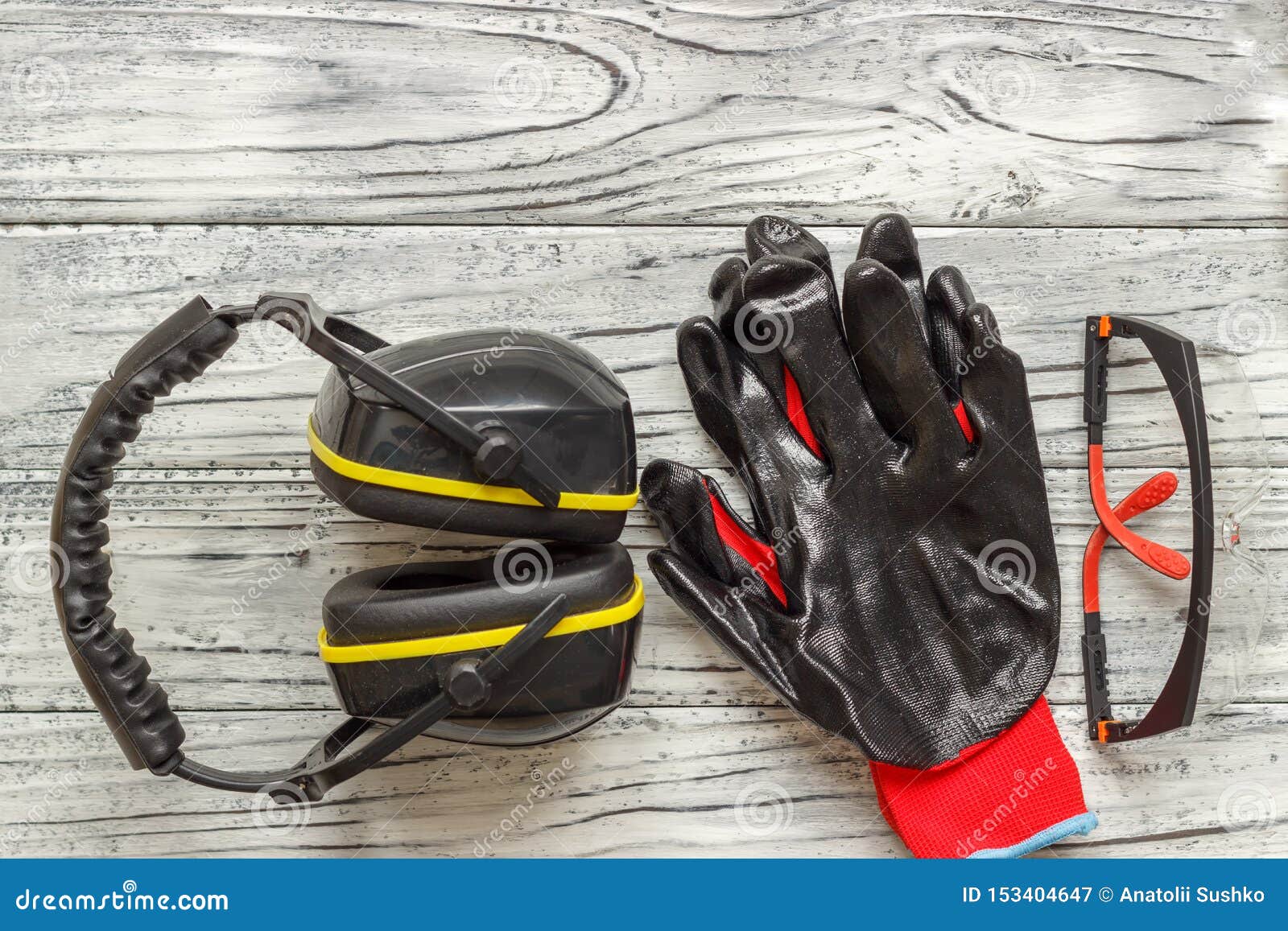 Personal Protective Equipment: Black Gloves Glasses on a Wooden