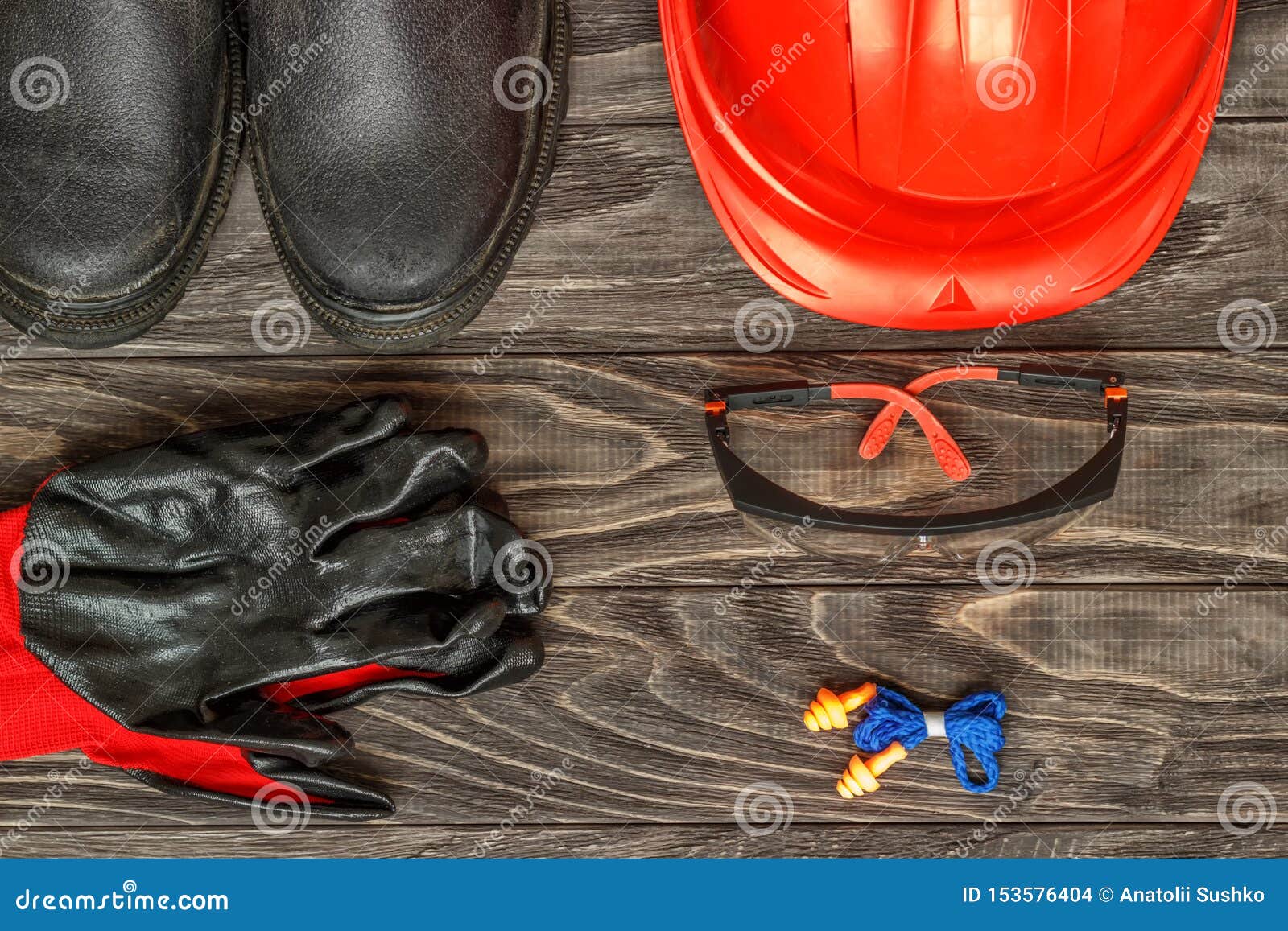 personal protective equipment: black gloves protect the glasses of the helmet on a wooden background