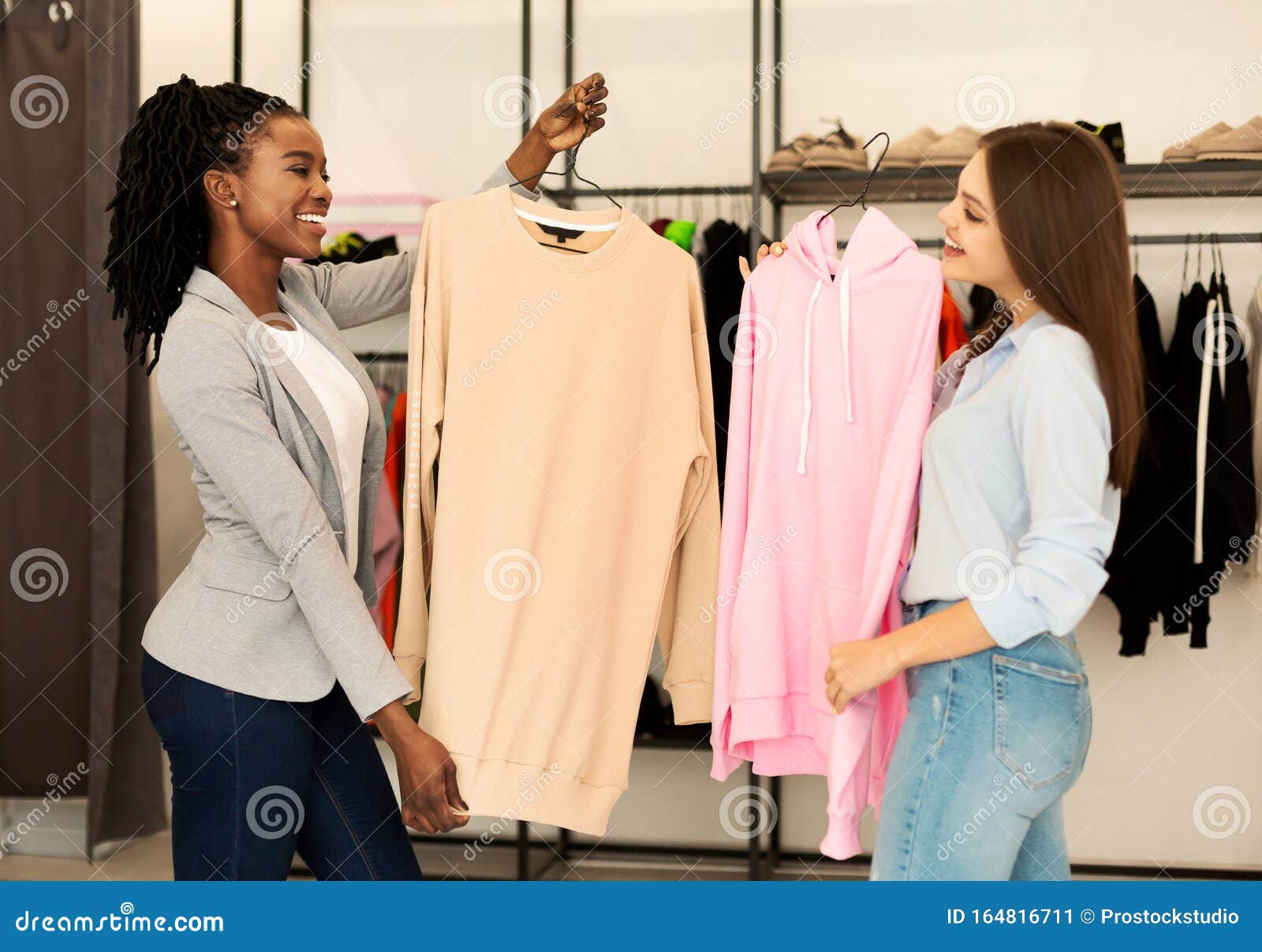 personal stylist and her client choosing updates in clothing boutique