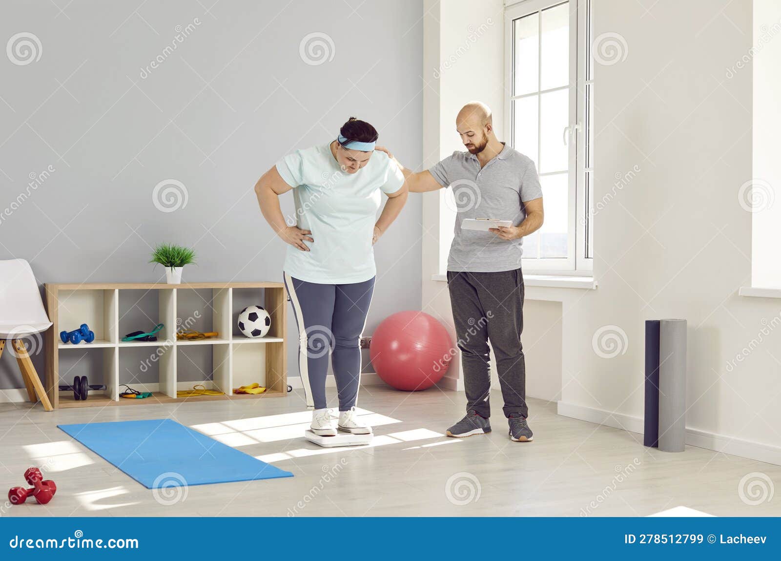 personal trainer evaluating health of overweight young woman