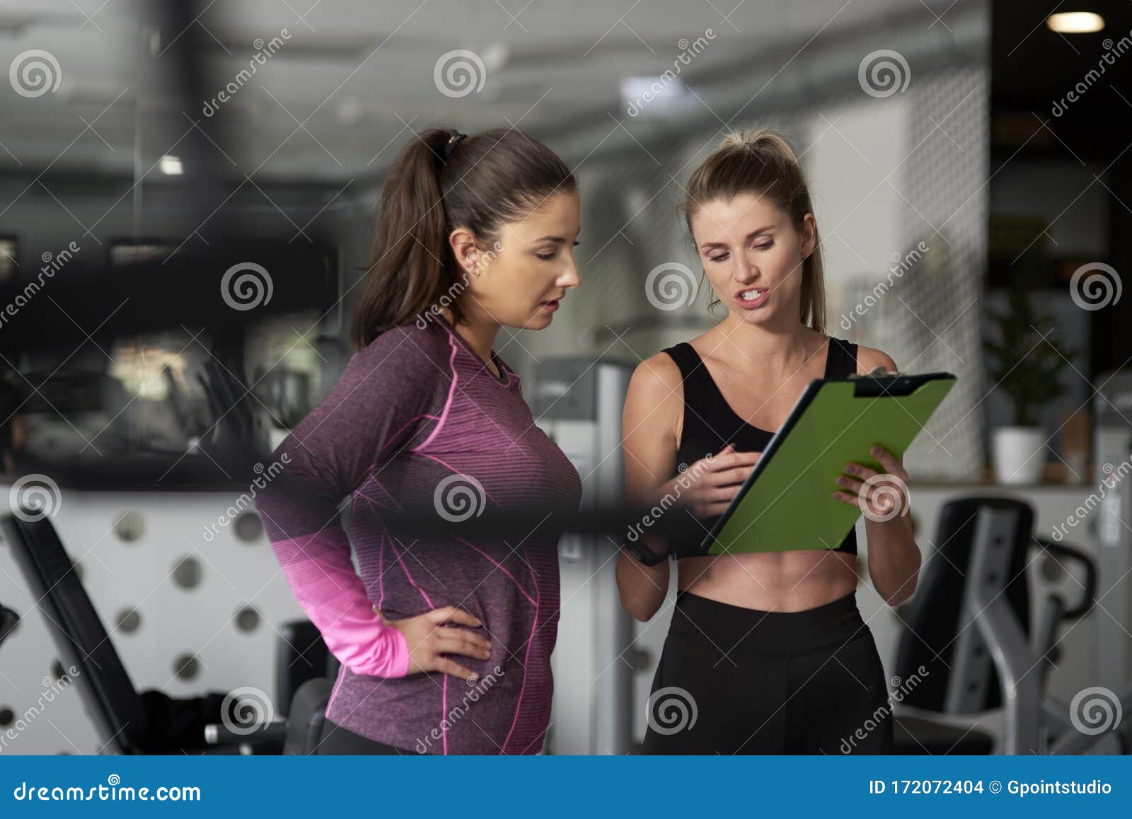 personal trainer guiding young woman