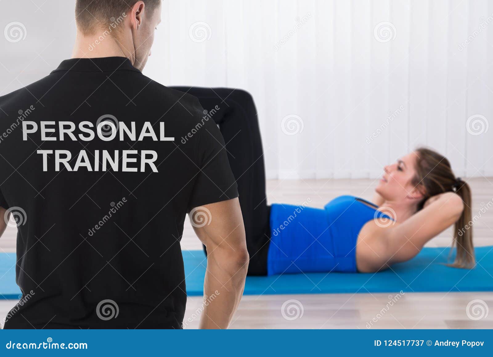 personal trainer looking at woman doing exercise
