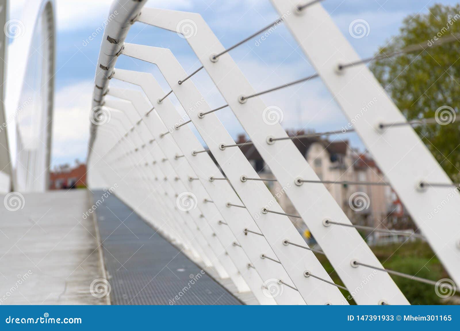 Perspective de recul sur des balustrades sur un pont avec un passage couvert piétonnier vide dans un milieu urbain