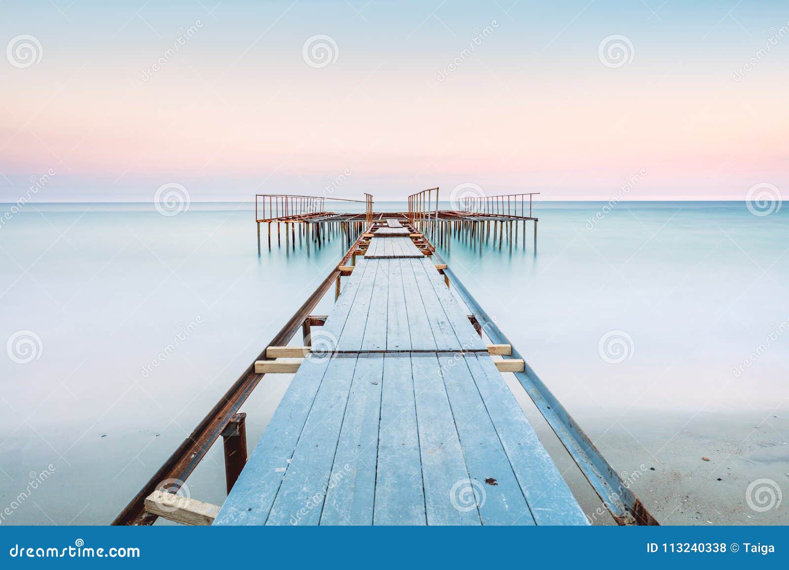 long esposure view of a old jetty in a calm sea with gentle sky, soft colors