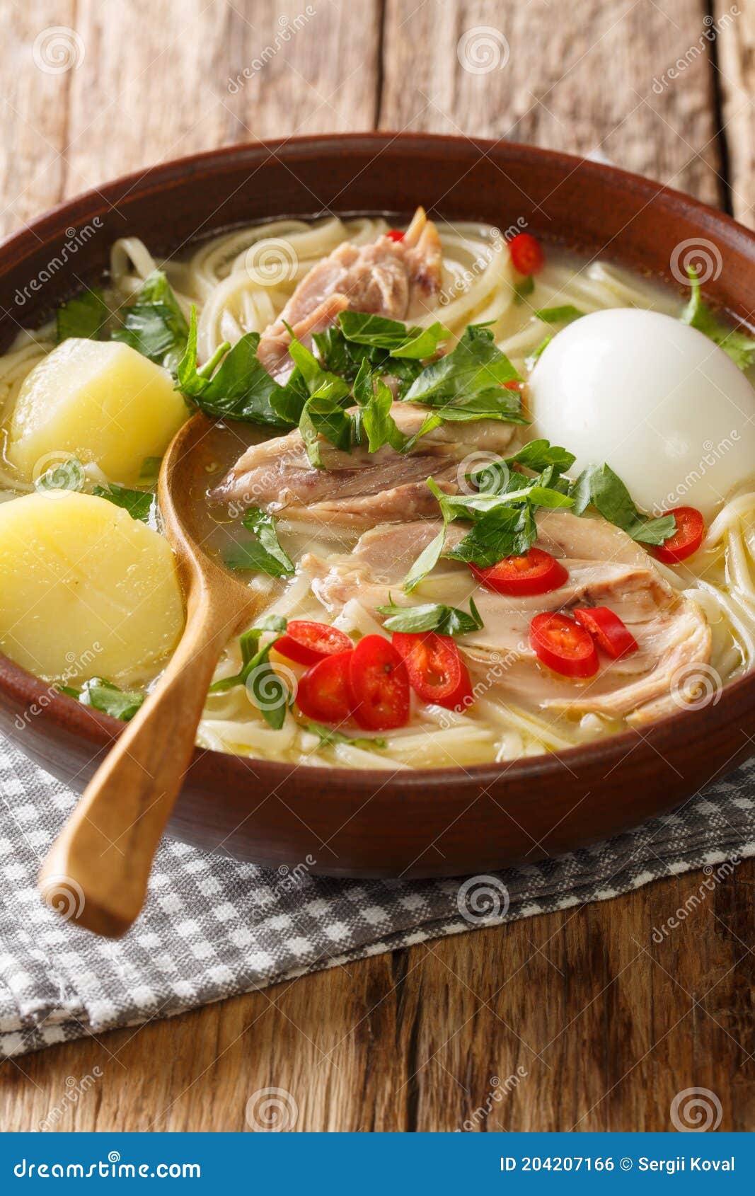 peruvian caldo de gallina chicken noodle soup close-up in a plate. vertical