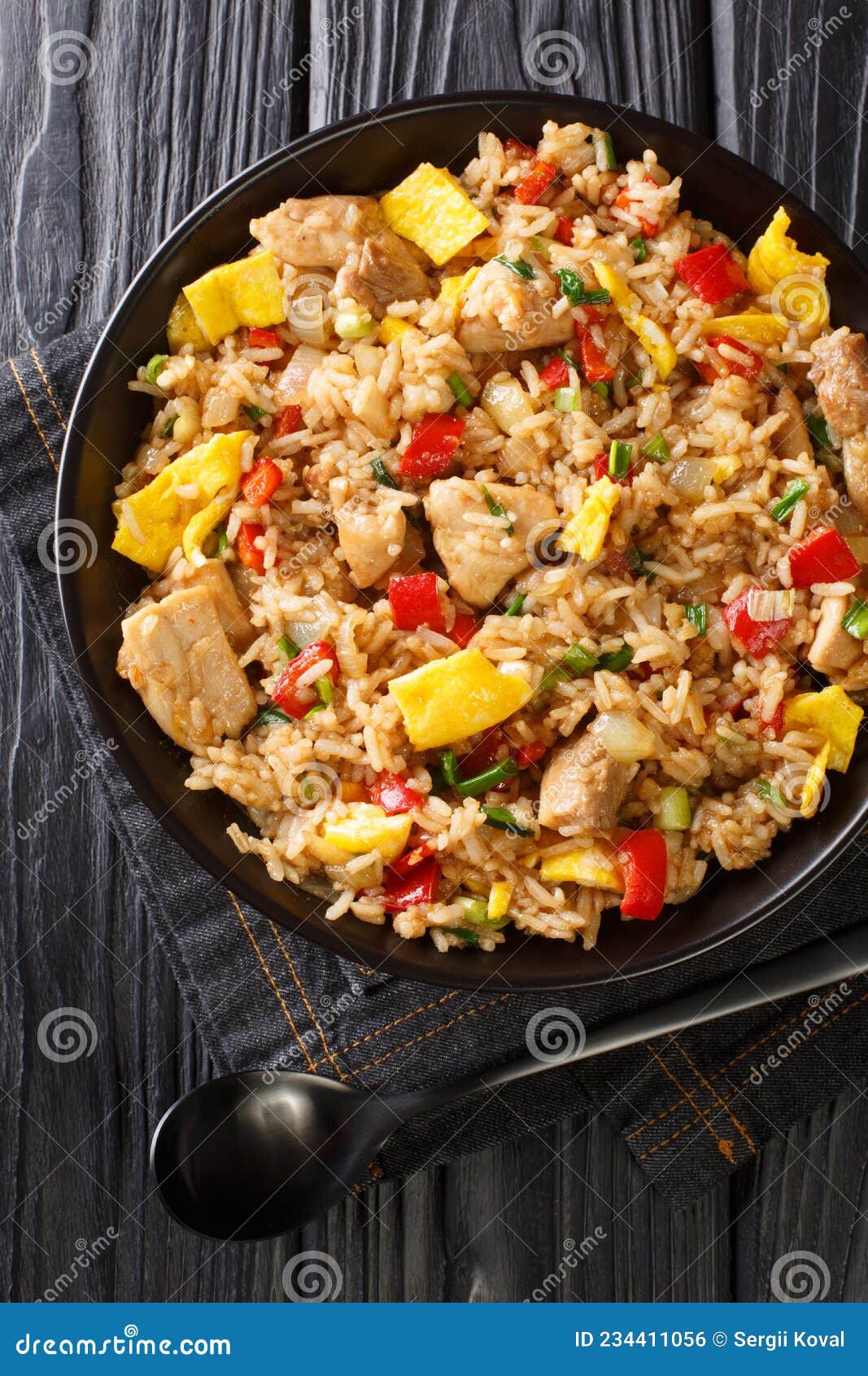 peruvian fried rice with meat and eggs arroz chaufa close up in the bowl. vertical top view