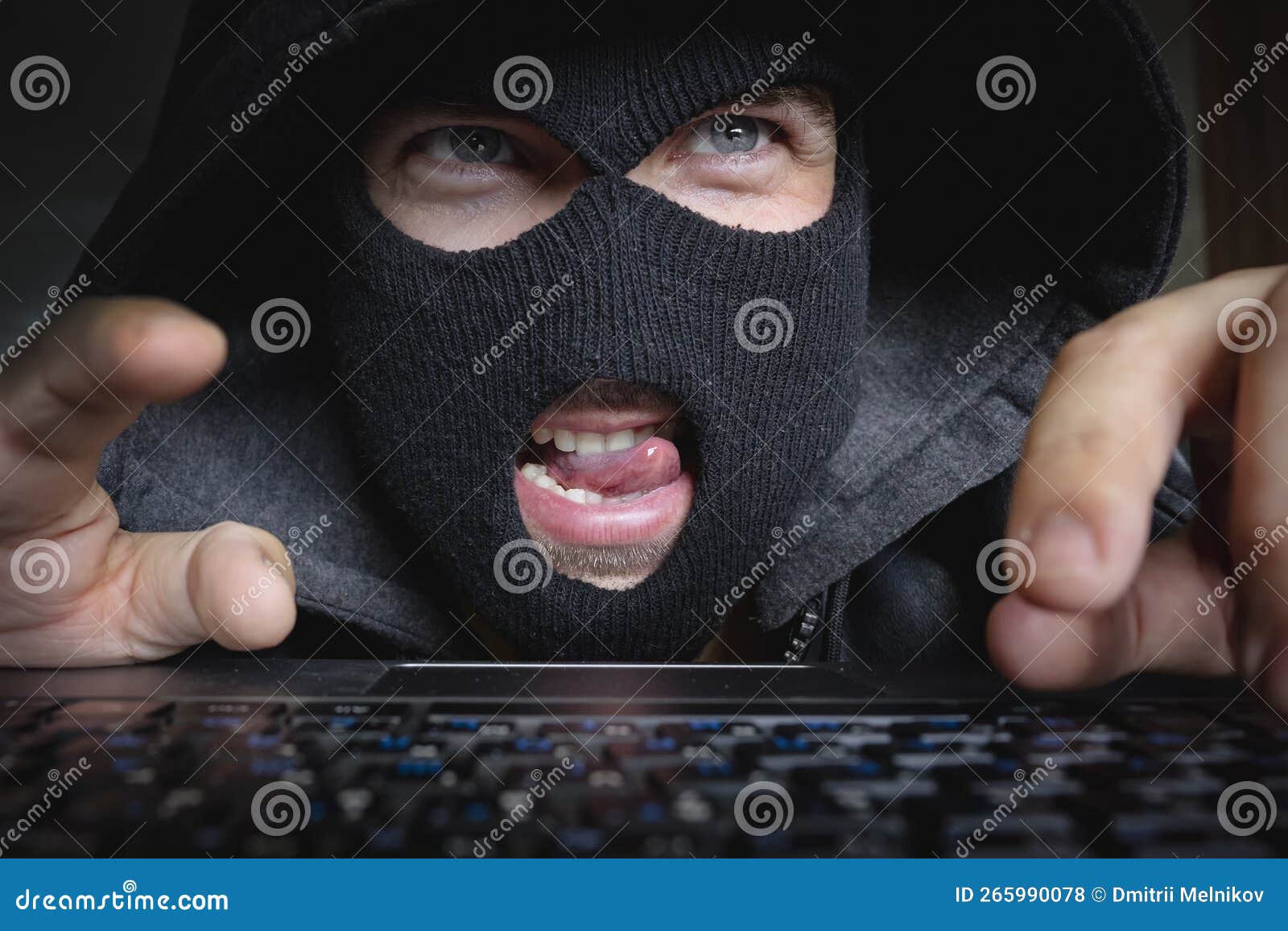 Pervert Maniac or Hacker Sits in the Dark at a Computer and Looks at the Screen Stock Photo