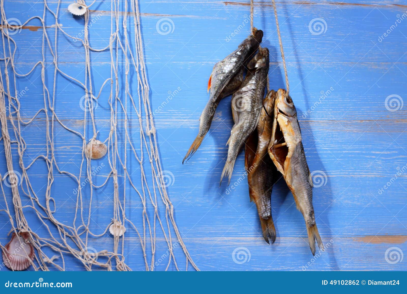 Pesce del rudd e rete da pesca secchi su fondo blu, orizzontale