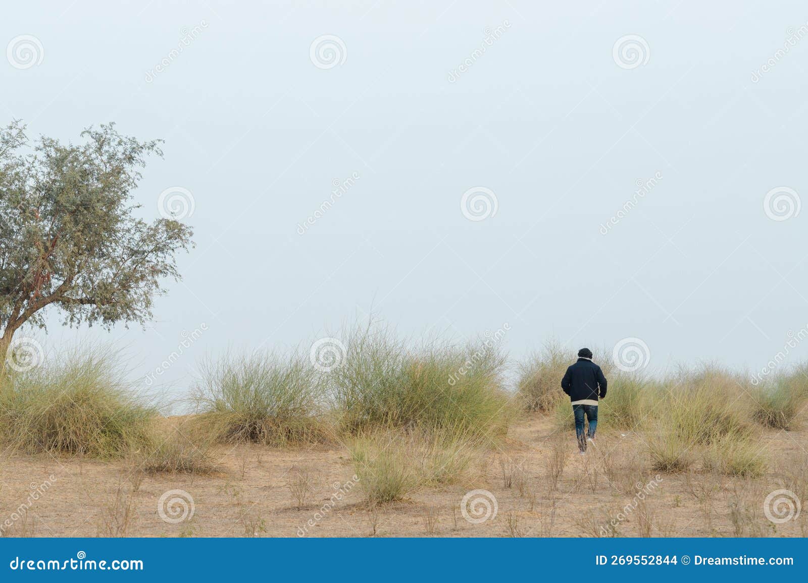 Pessoa Correndo Em Um Campo Seco Com Gramíneas Se Amontoando Foto de Stock  - Imagem de paisagem, céu: 269552844